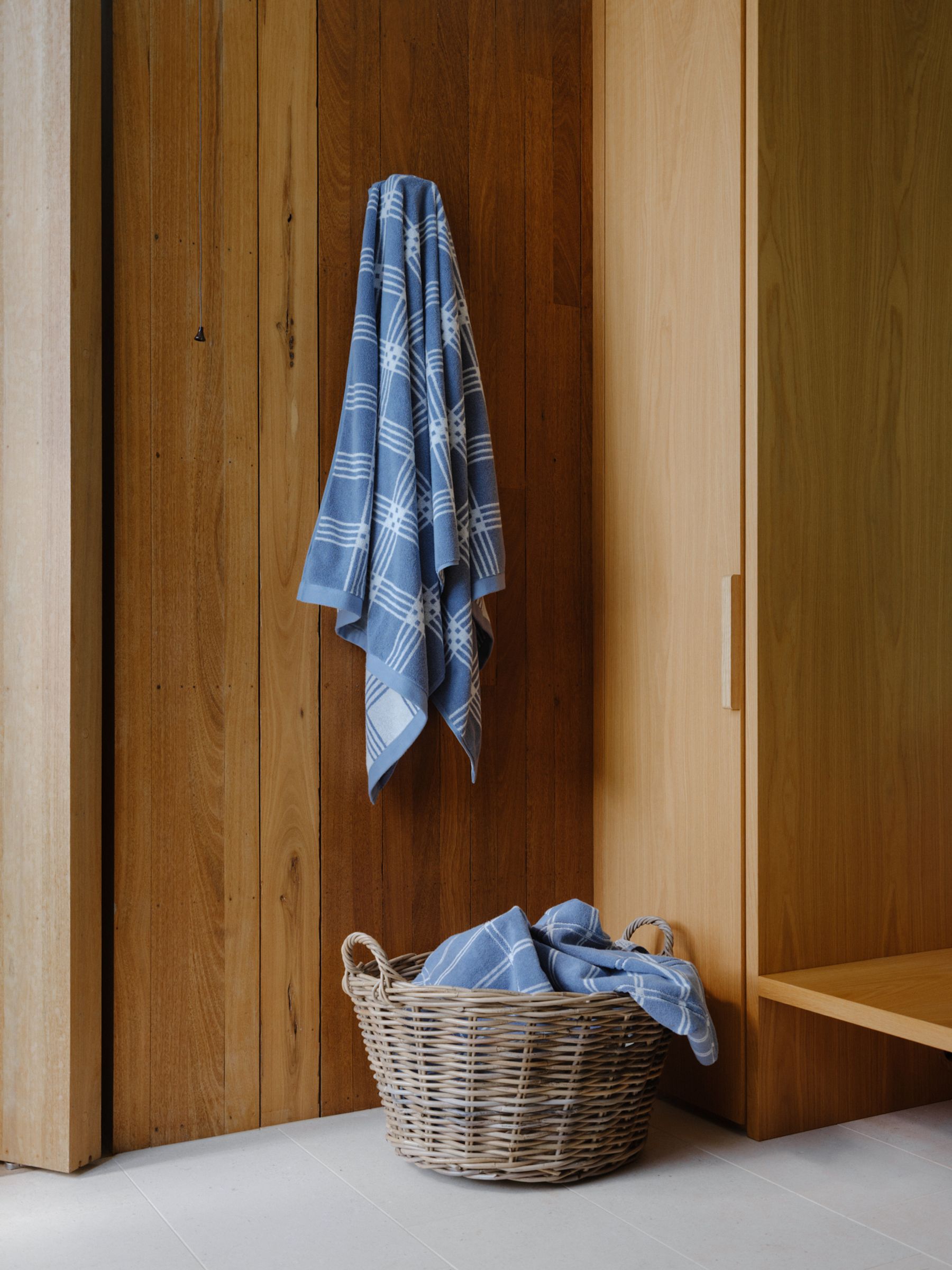 baina tartan towels hang on door handle and lay ruffled in basket