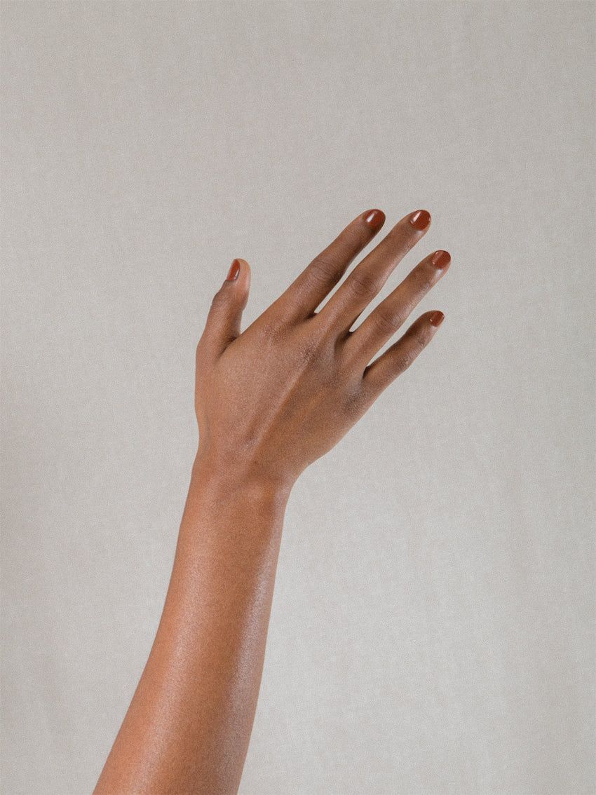 Close-up of a hand with nails painted in a natural shade, highlighting the smooth texture of the skin. The lighting emphasises the high-quality polish from J. Hannah.