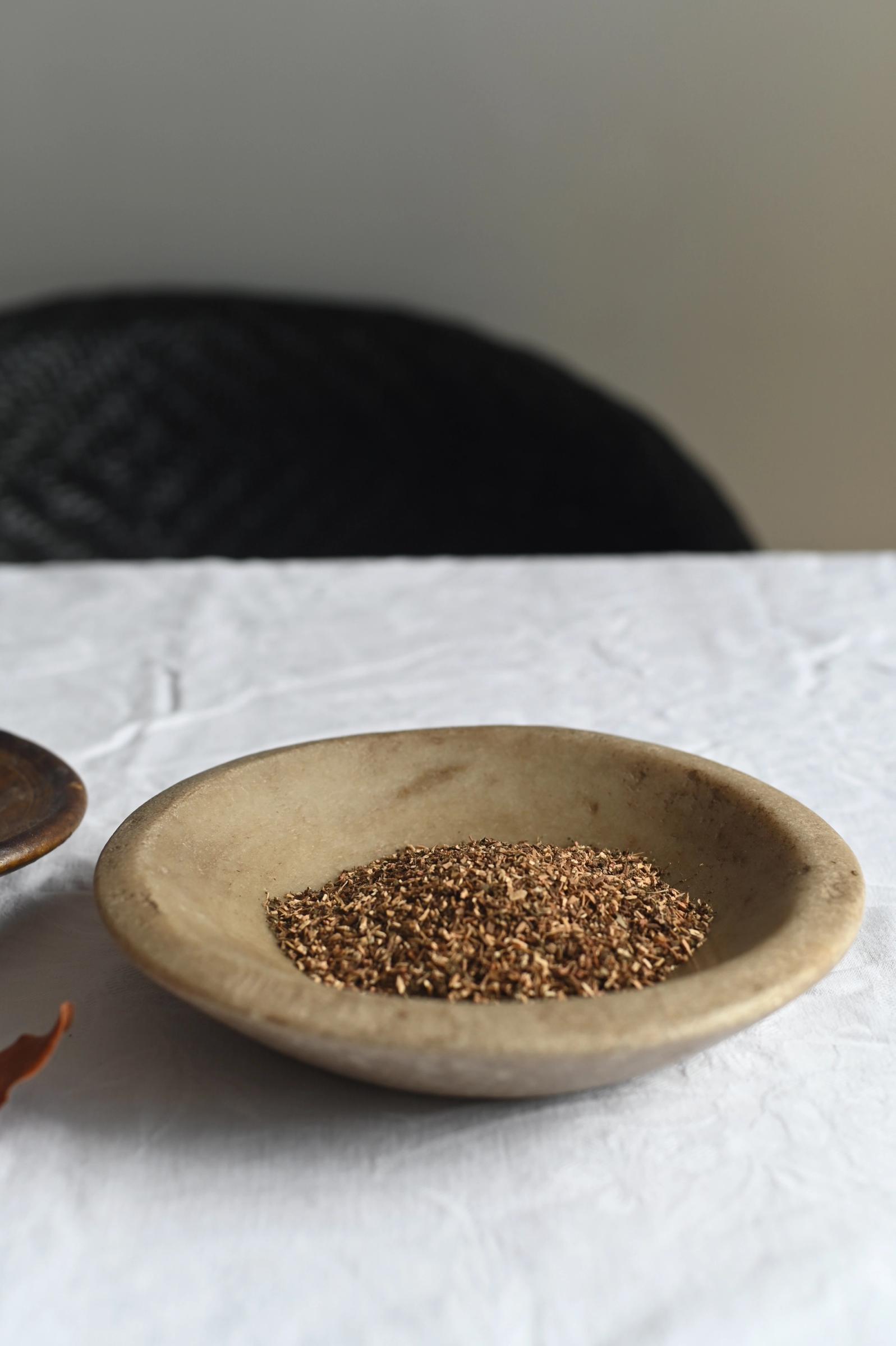 a pale brown bowl sits on table filled with potpouri