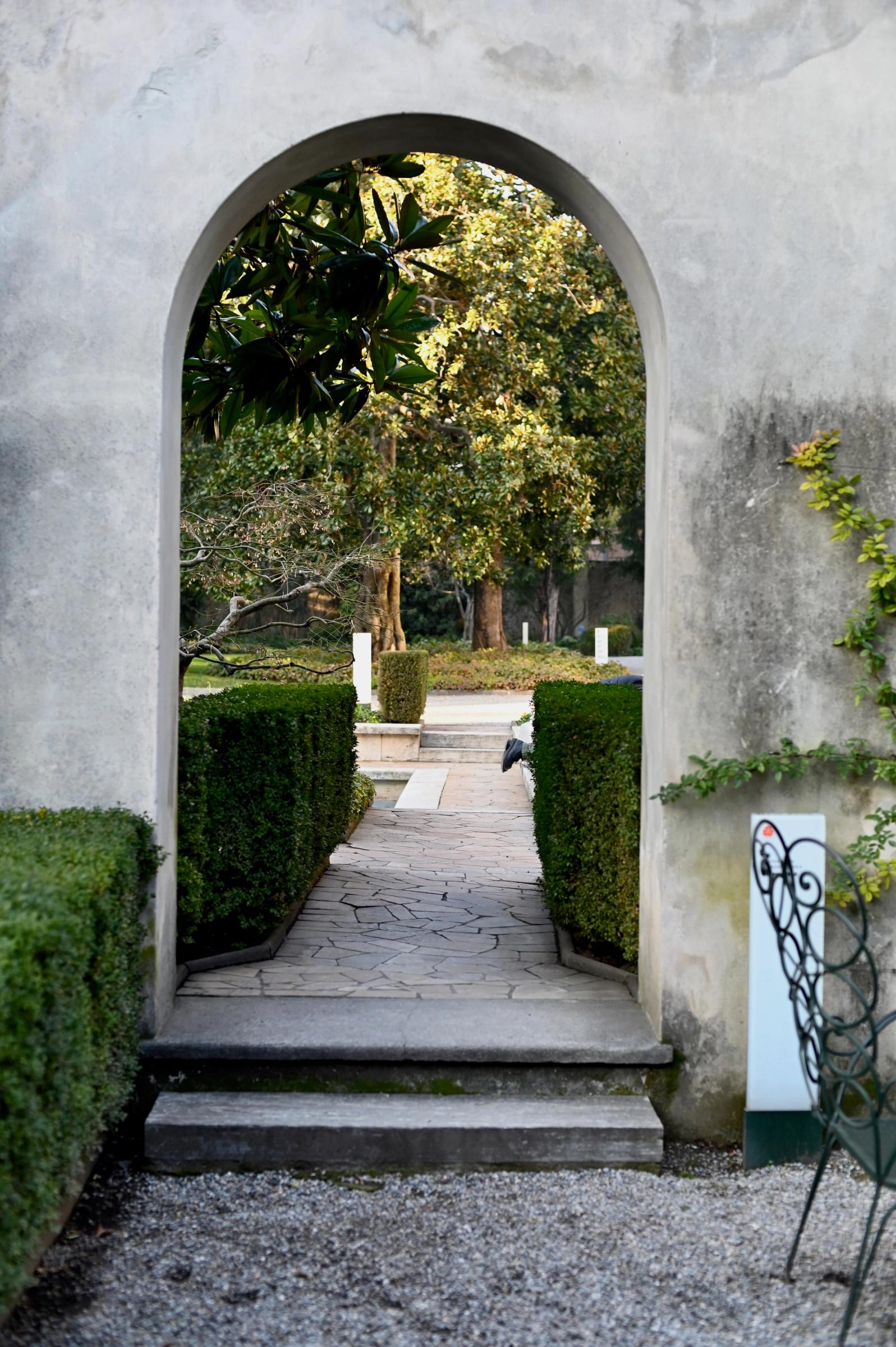 a stone archway leads to the garden path