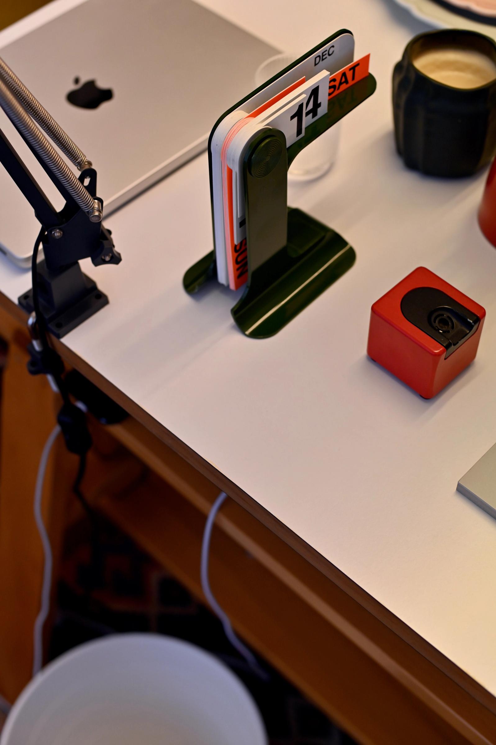 dieter rams calendar sits beside an apple laptop on the desk