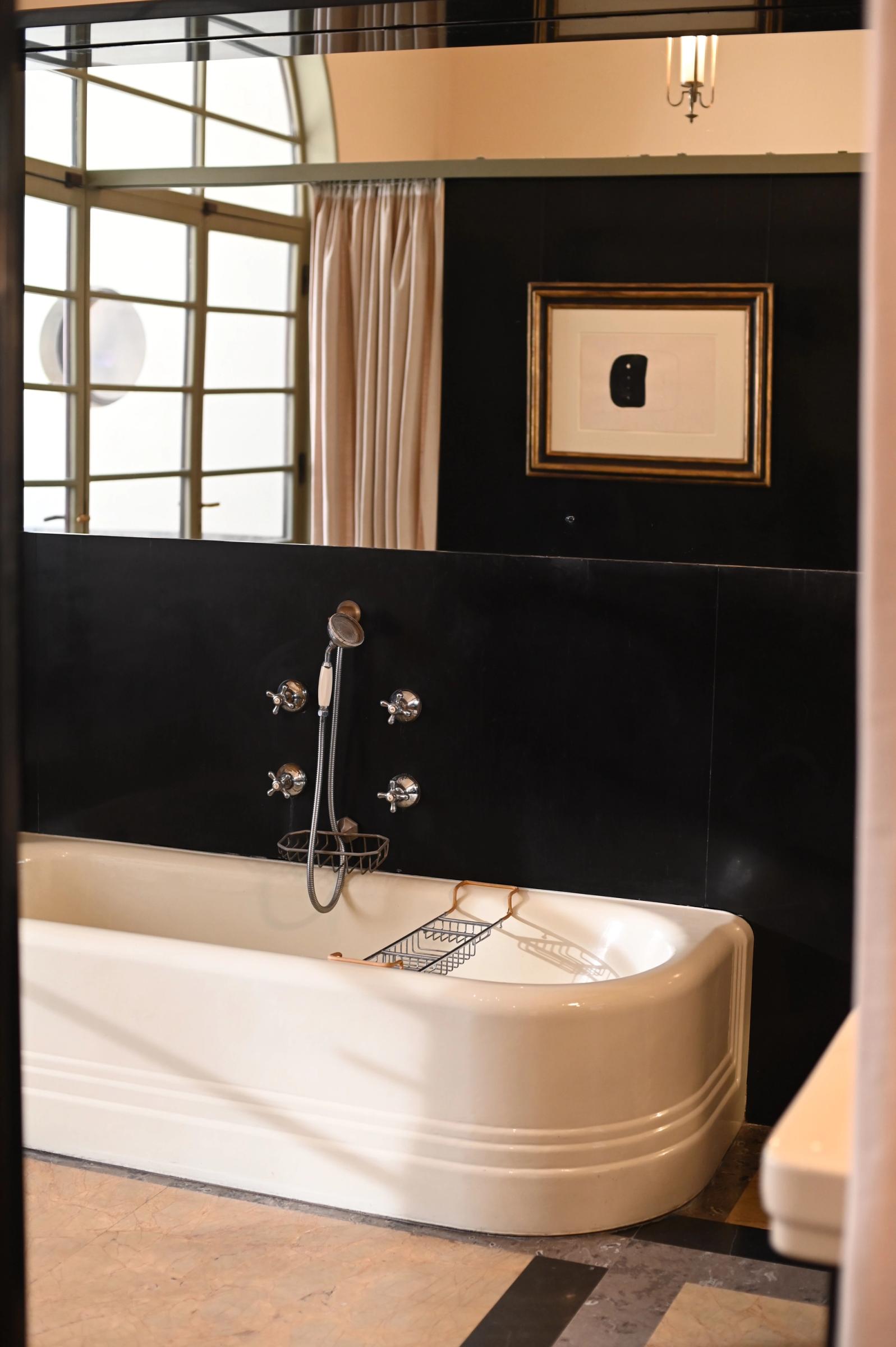 a black bathroom with a white bath reserved for guests