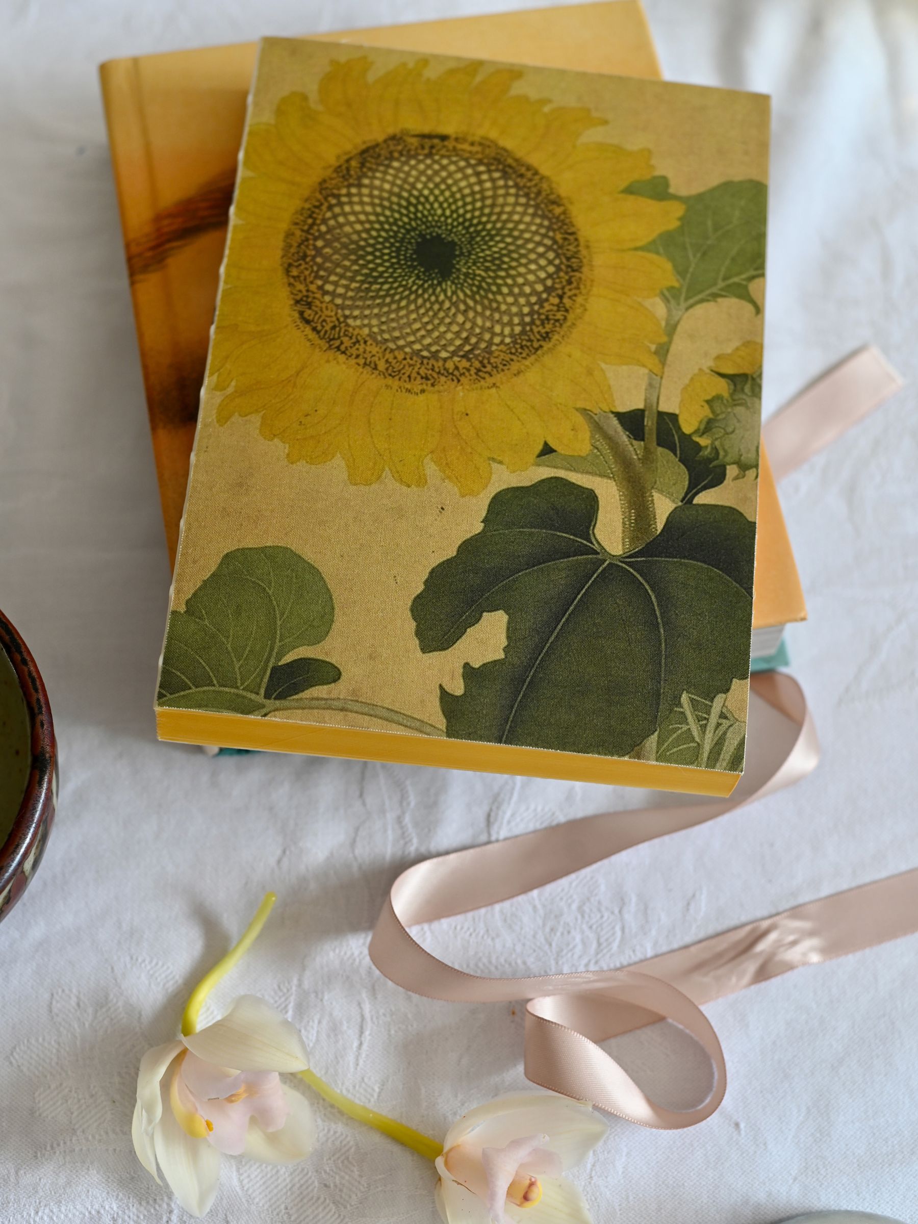 Sunflower Notebook on white tablecloth in natural light