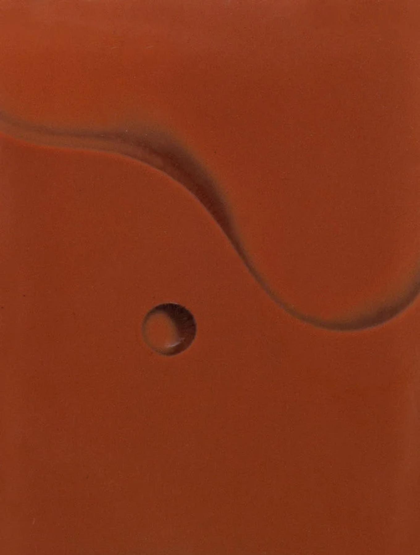 Abstract image with warm orange tones, subtle curved line, and small circular indentation in centre.
