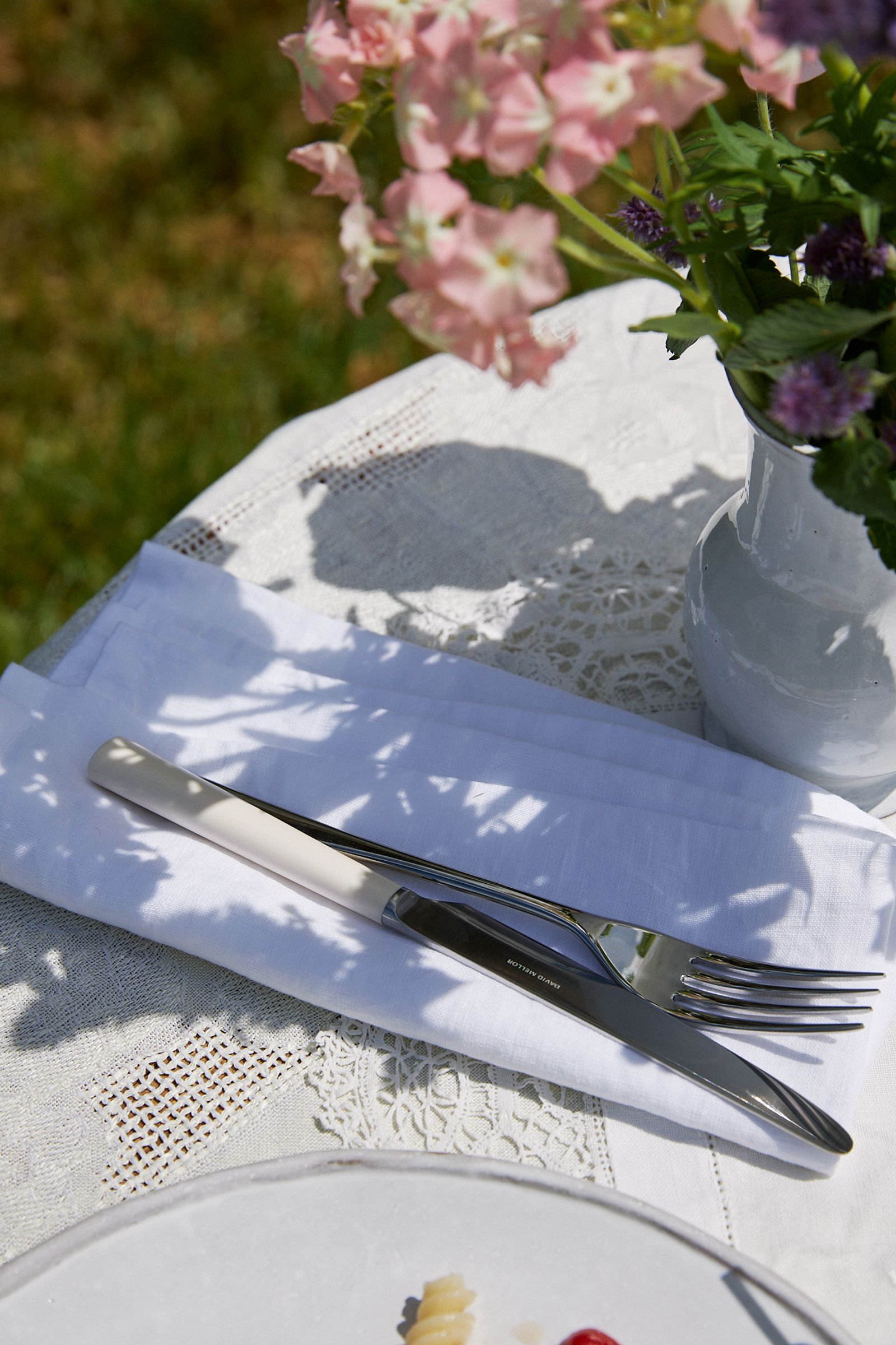 a white vase sits on the table with freshly picked garden blooms