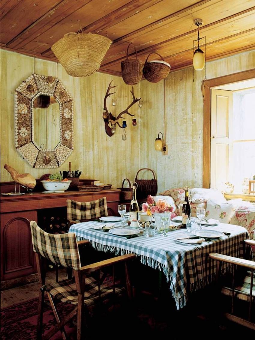 Cozy holiday dining room with wooden decor. Blue checkered tablecloth set for meal. Wicker baskets and antlers on walls.