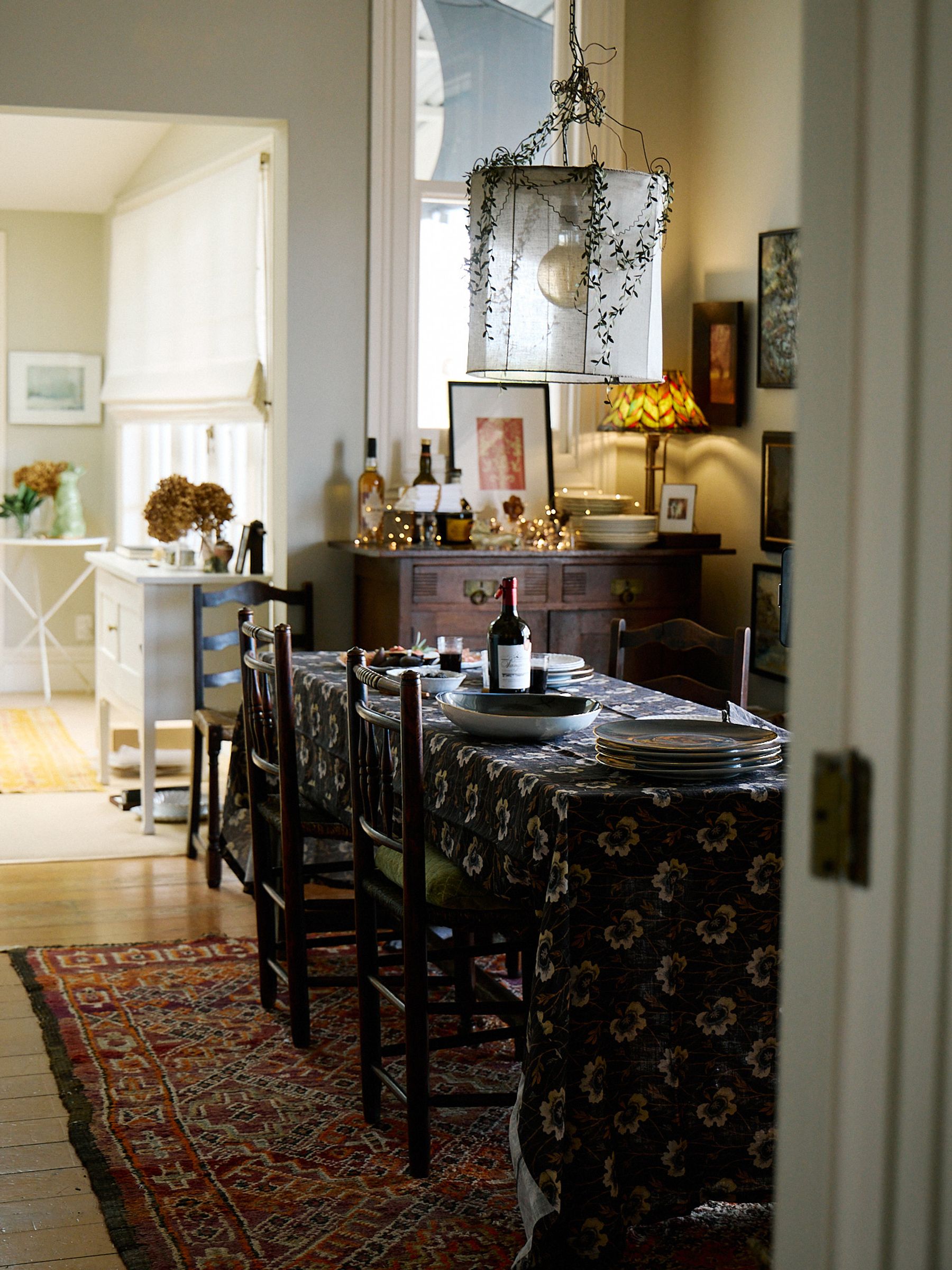 wide shot of room with large table covered in dark floral tablecloth