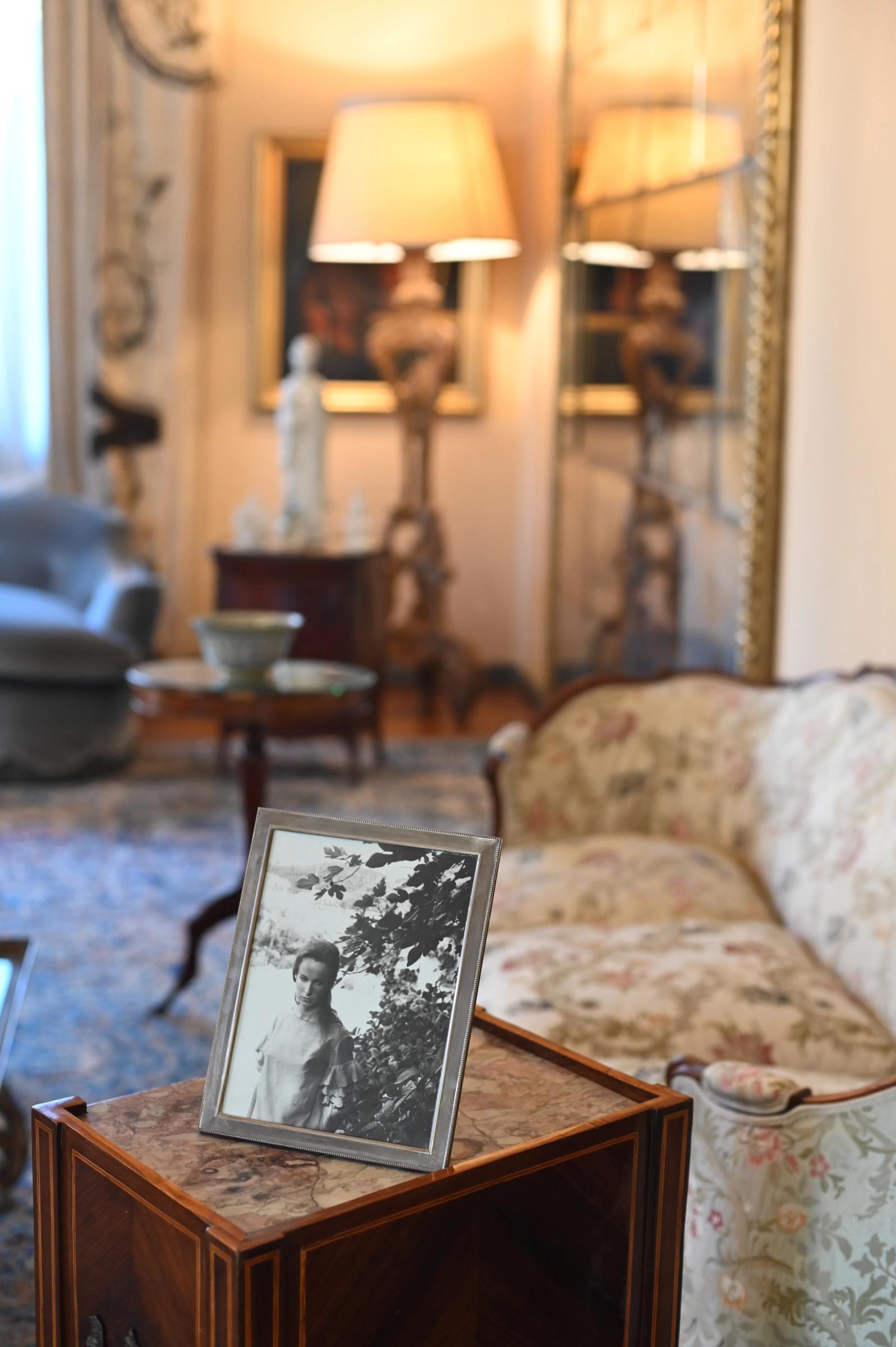 a black and whit photograph in a silver frame sits on a wooden plinth in the lounge room