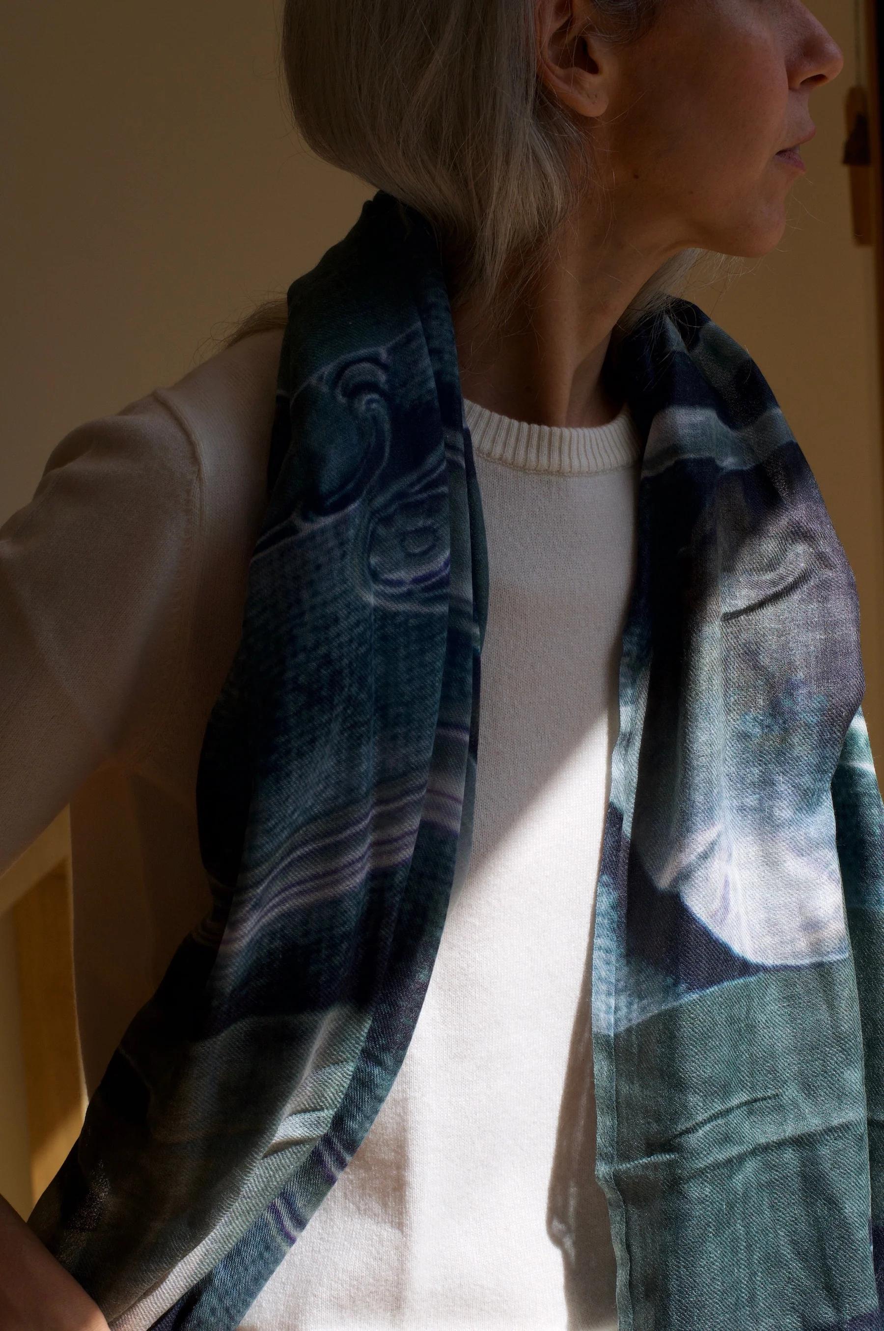 Person with light hair in white top and dark patterned Laing Home scarf. Standing sideways, showcasing autumnal loungewear.