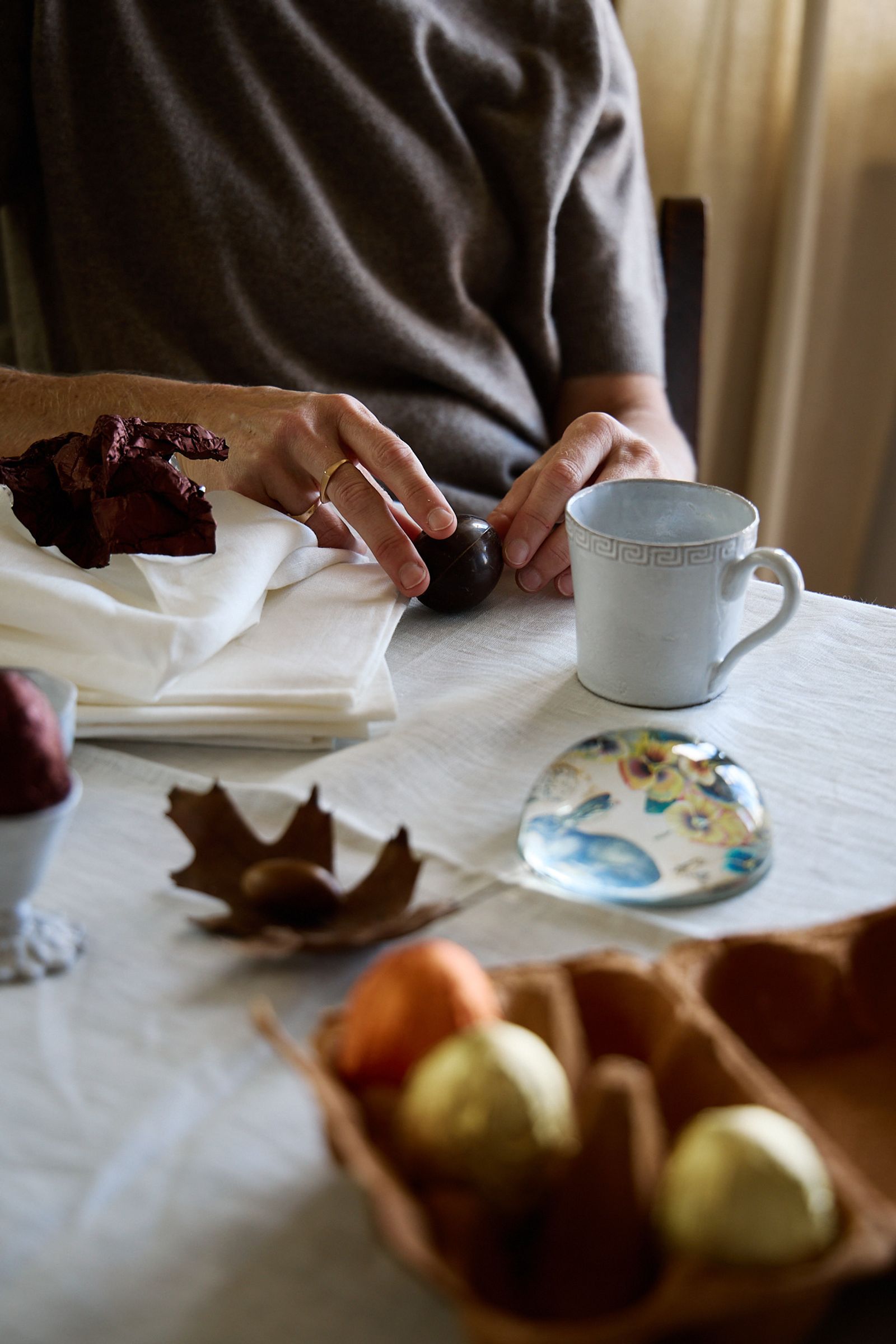 table laid with white cloth and easter eggs and mug of coffee