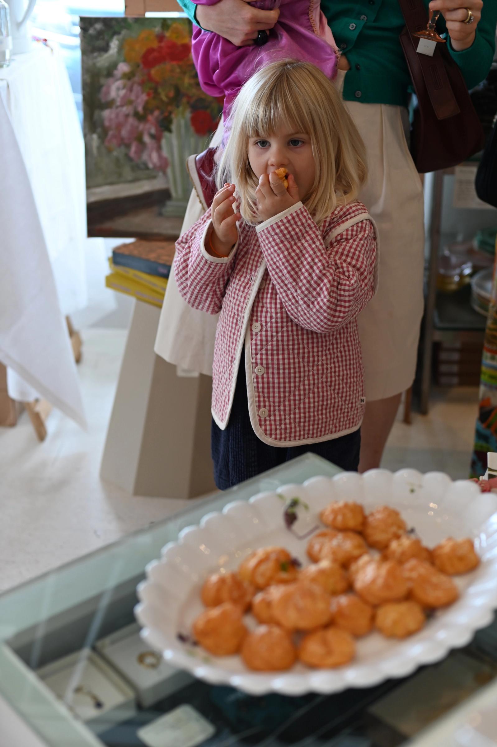 a small girl takes a bite of the event's delicious snacks