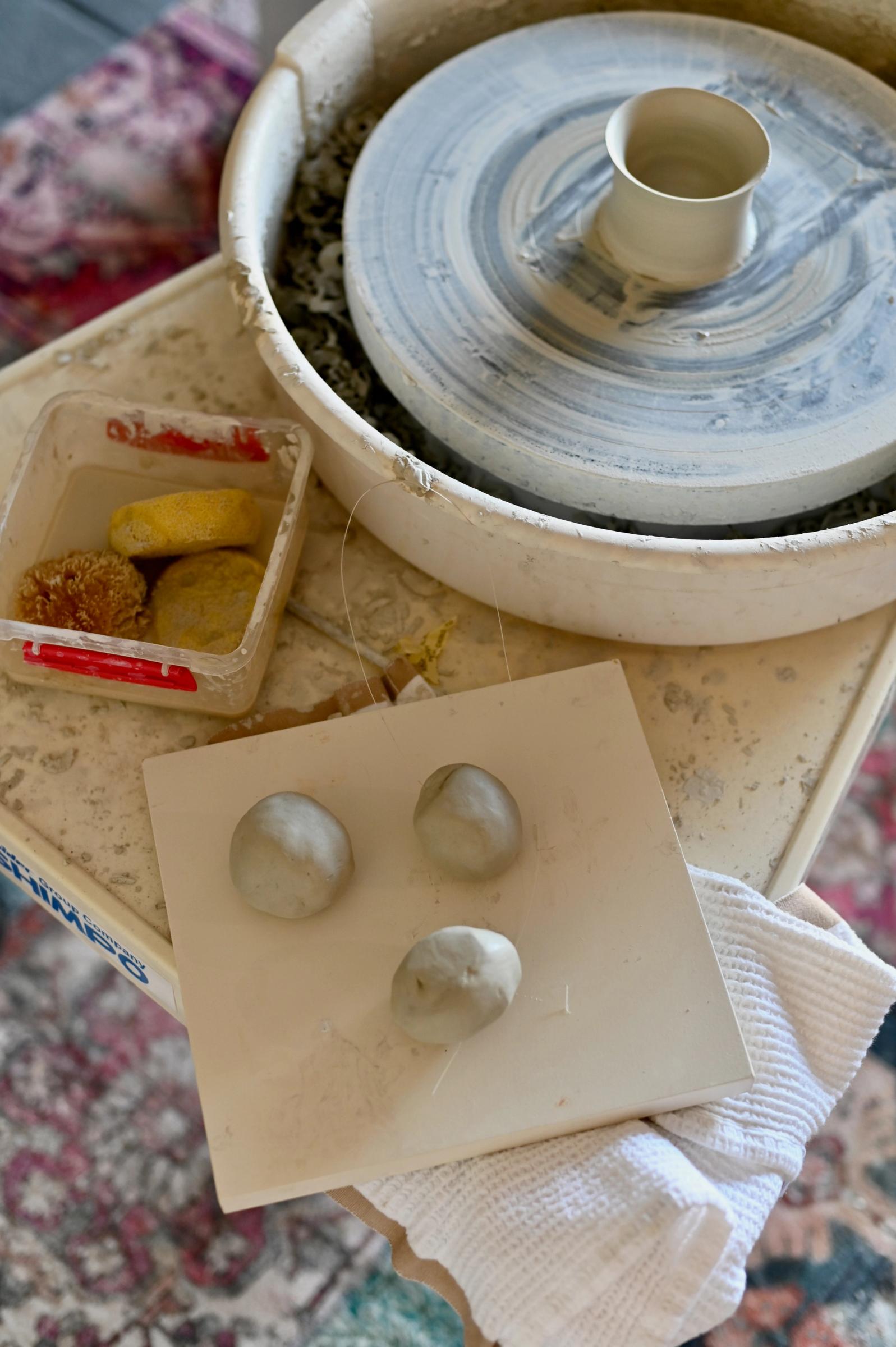 potters wheel and three balls of clay lay waiting to be turned