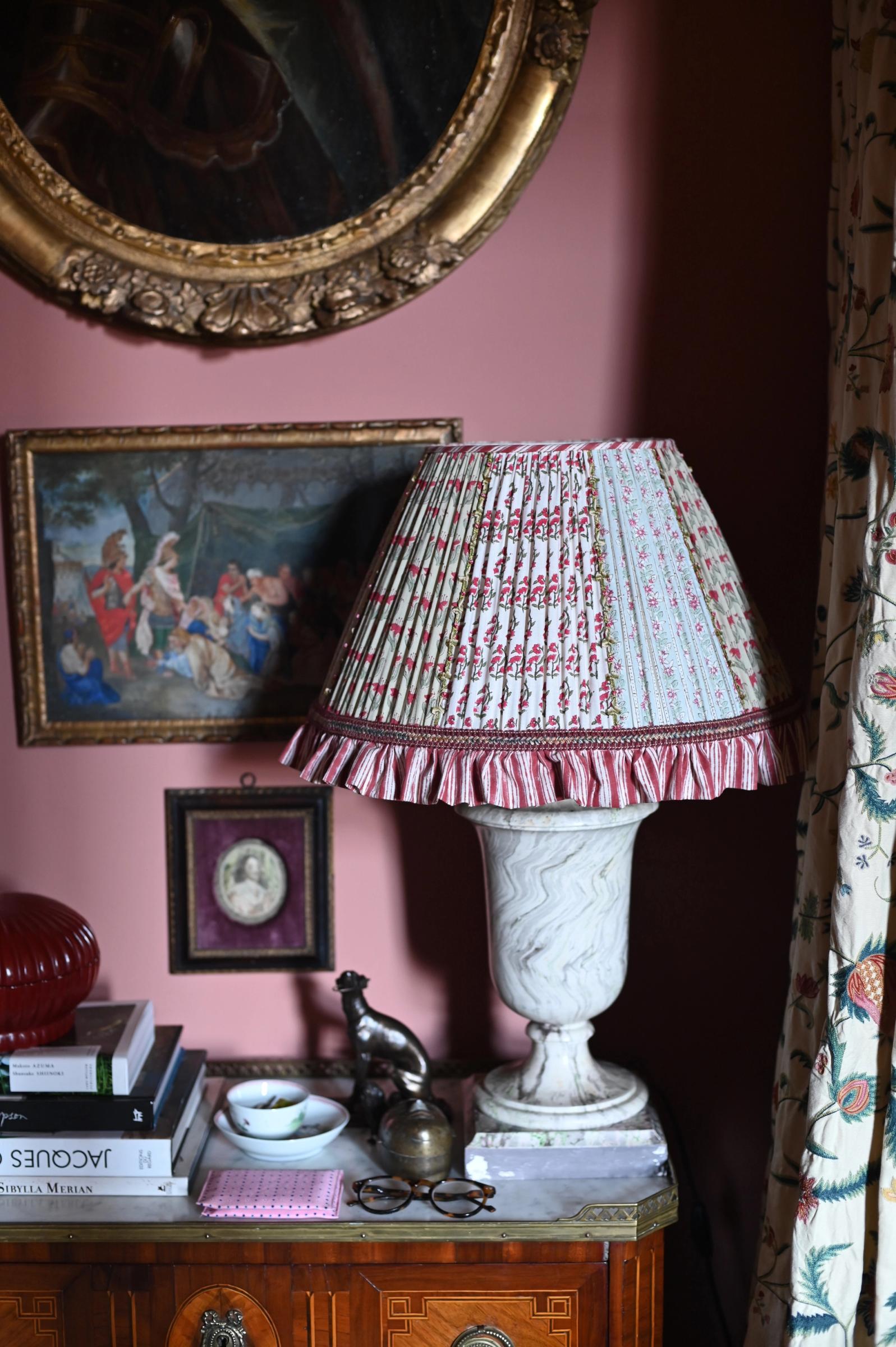 Handmade lamp on a bedroom dresser with glasses and books