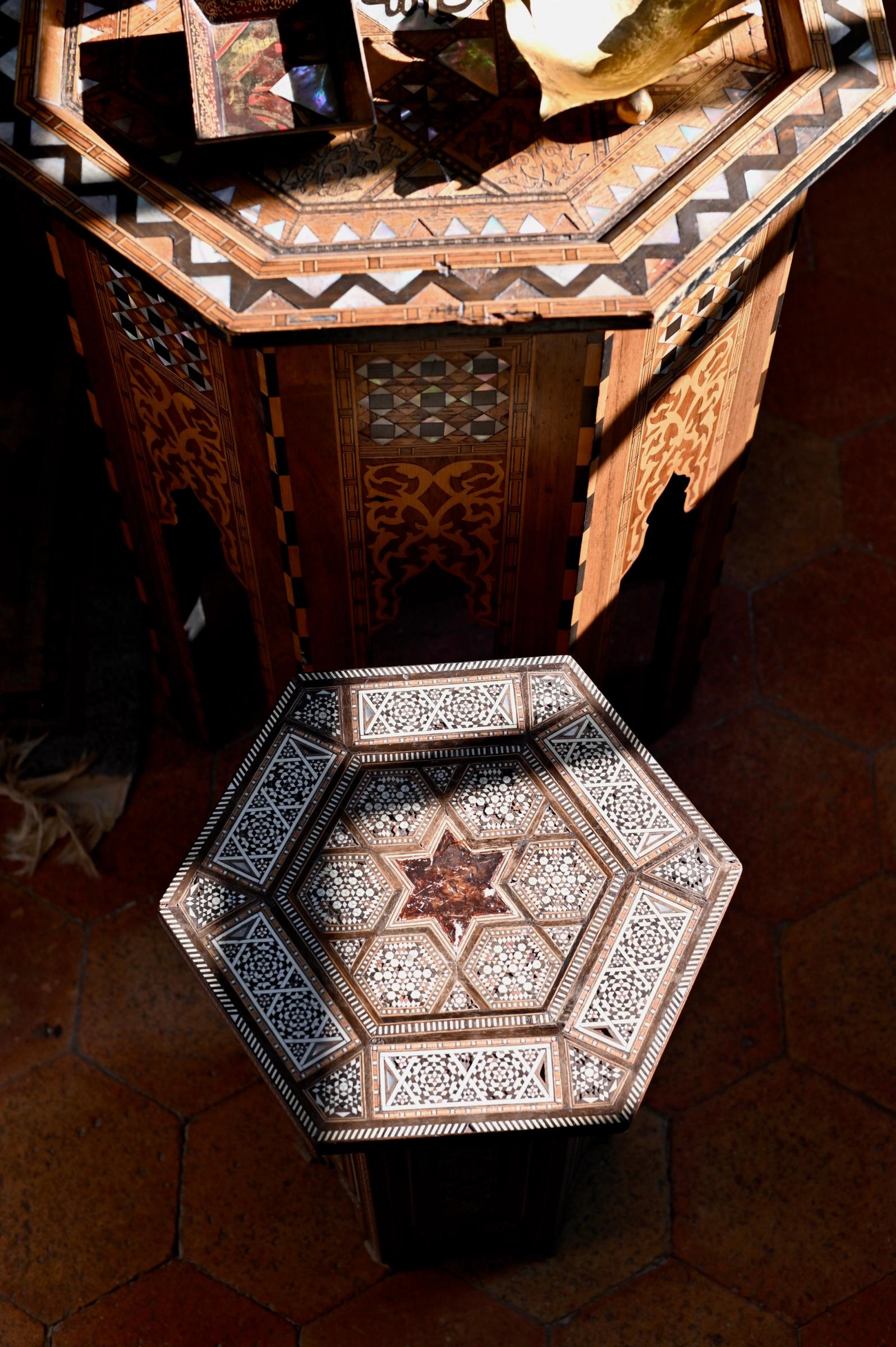 a small hexagon shaped table with shell inlay decoration
