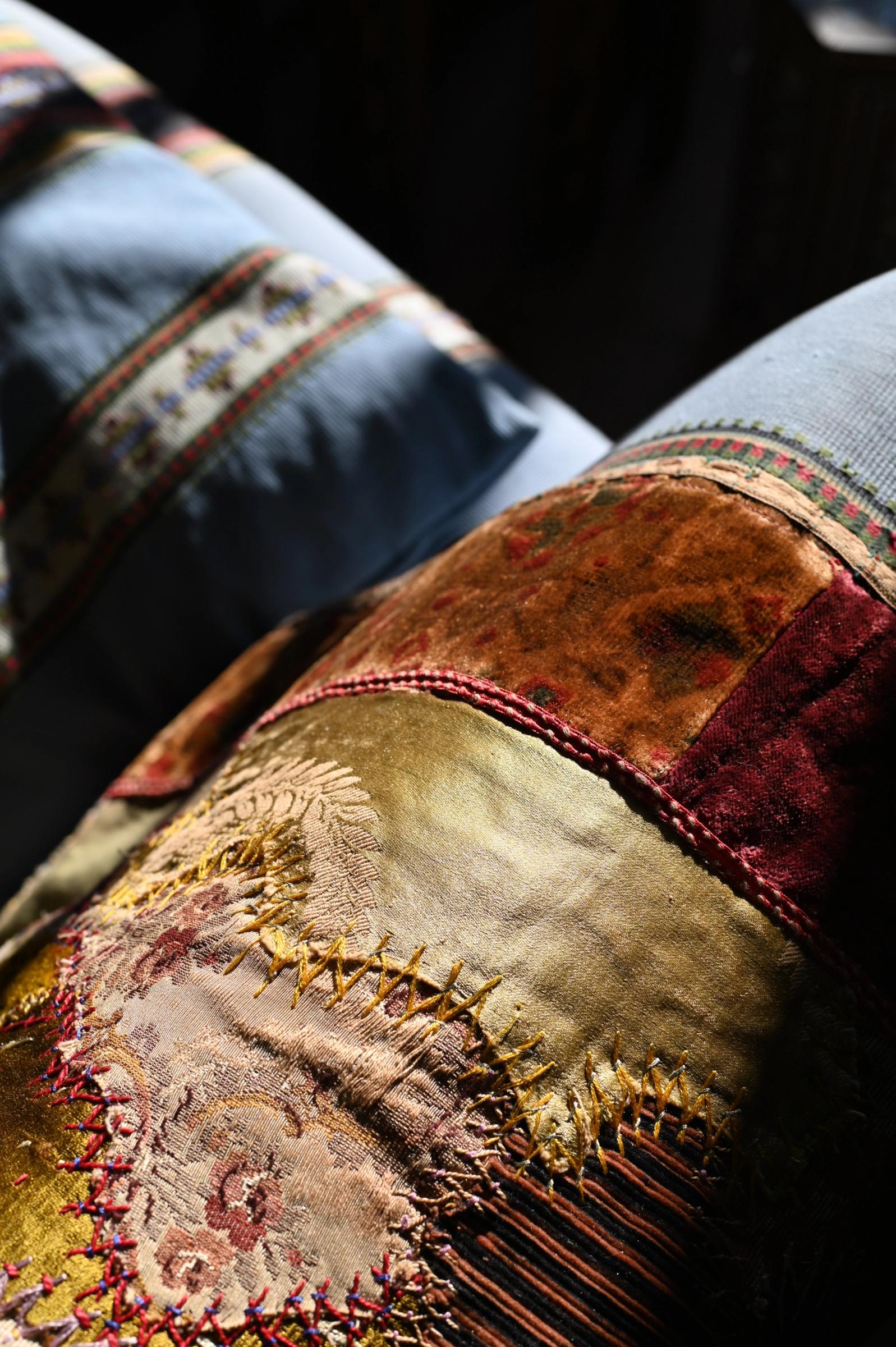 close up on richly textures antique textiles in gold amber and blue