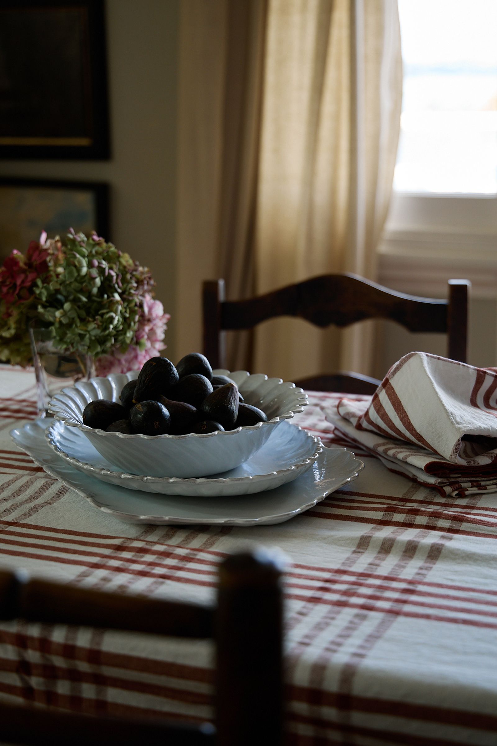 table laid in check cloth with bowl of fresh purple figs