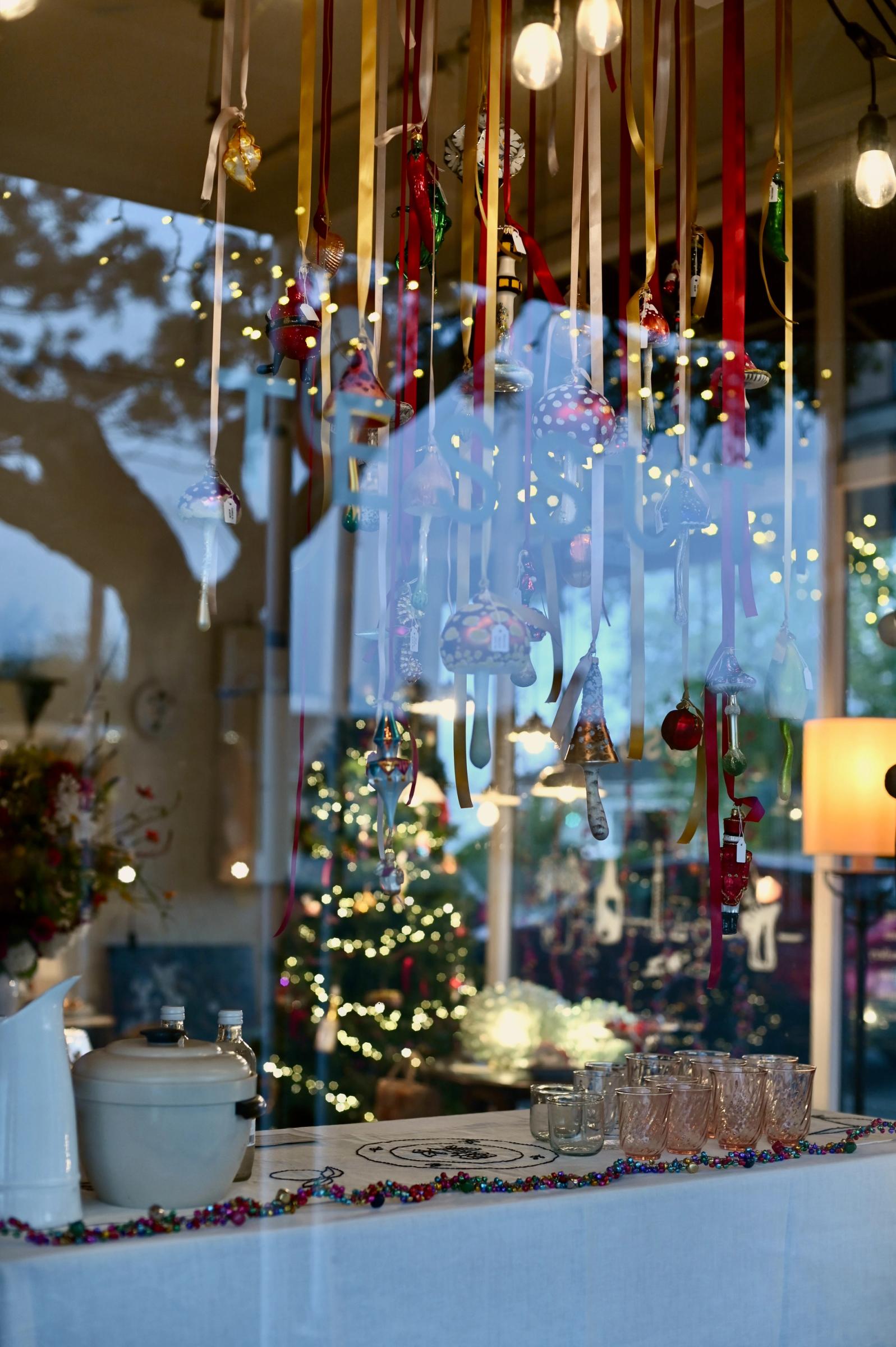 image taken through store window at christmas decorations hanging