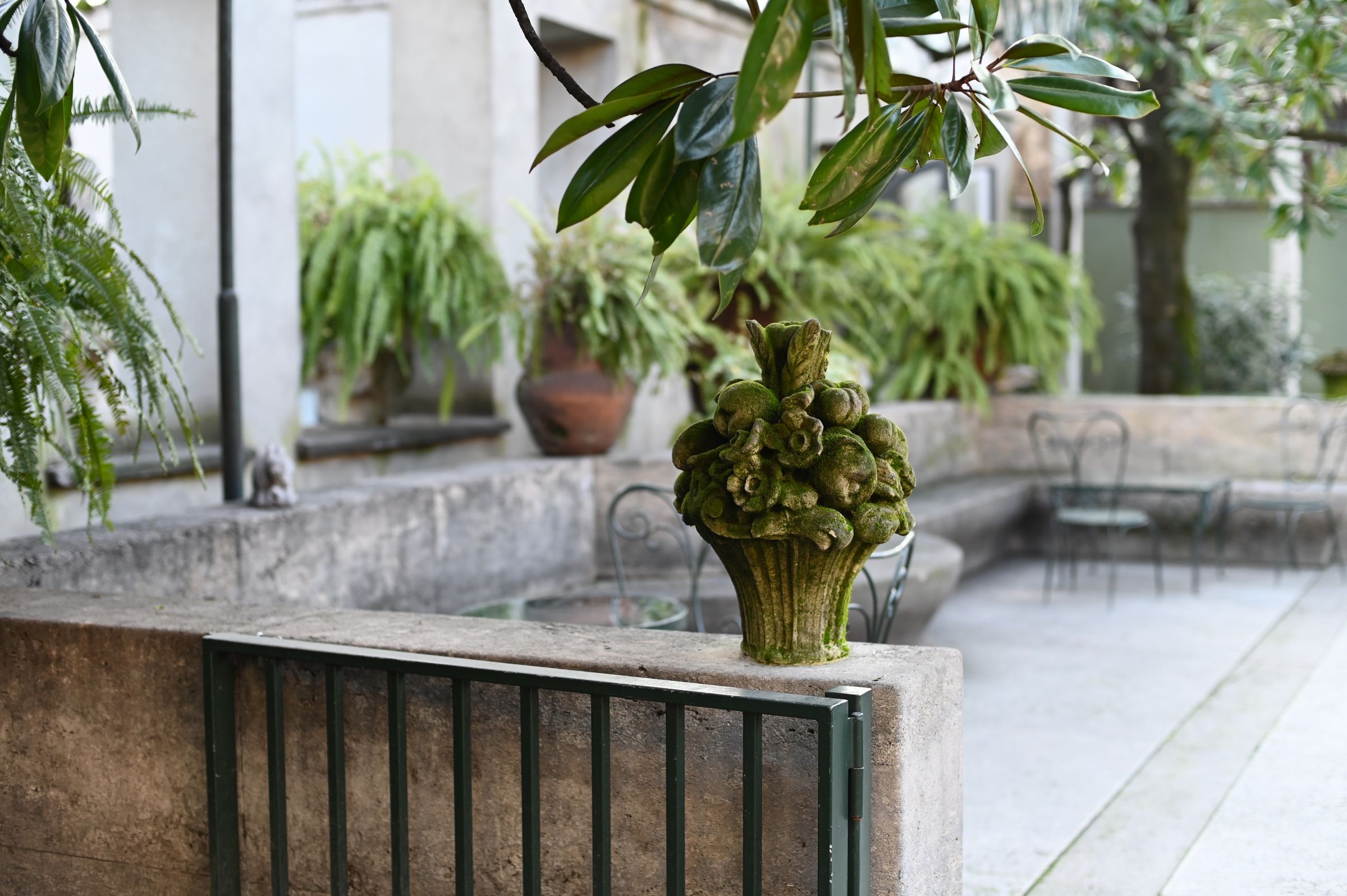 moss grows over a stone carved bouquet in the garden