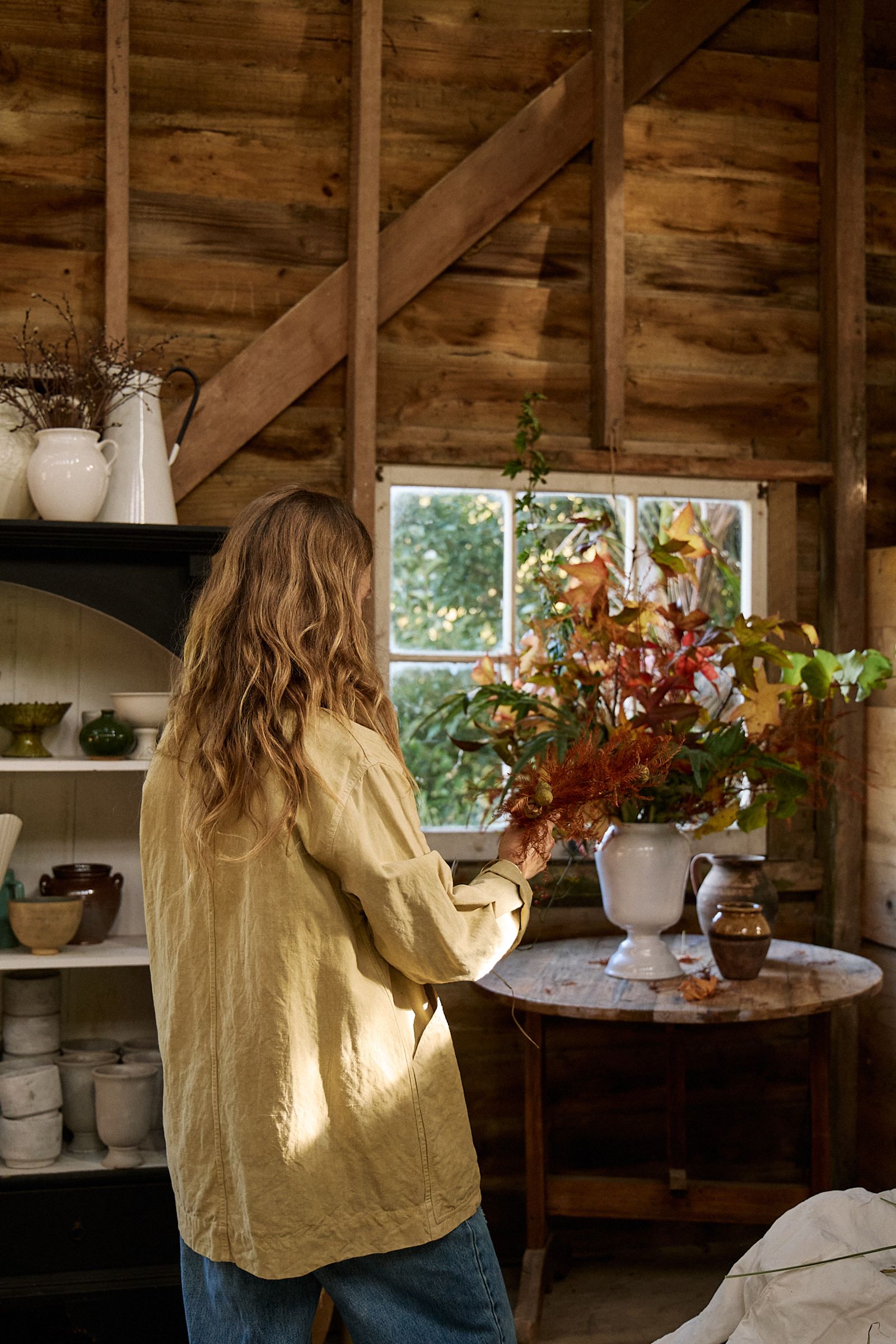 Aila installing a flower arrangement in an Astier de Villatte Apothecary vase