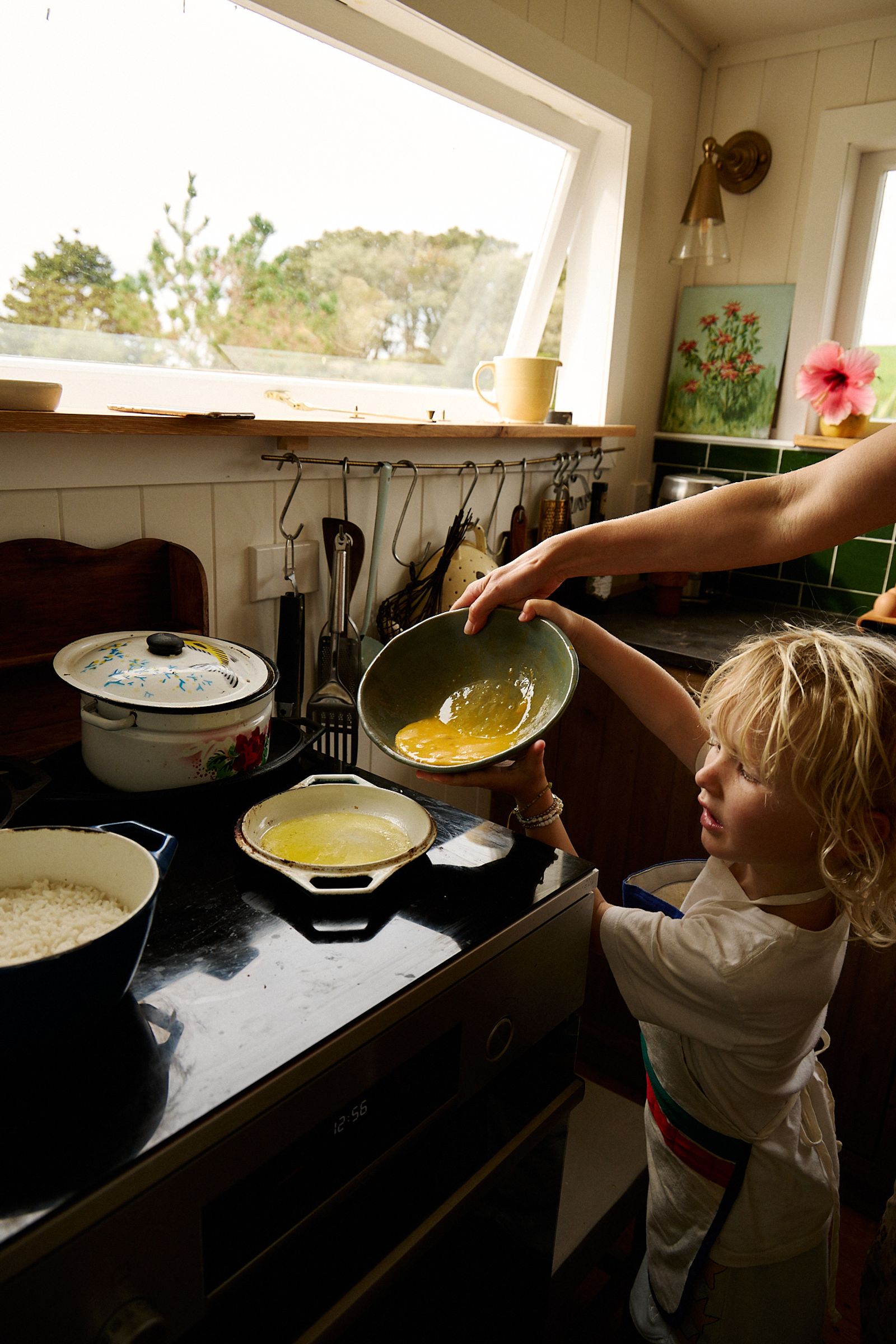 whisked egg goes into the pan with son helping too 