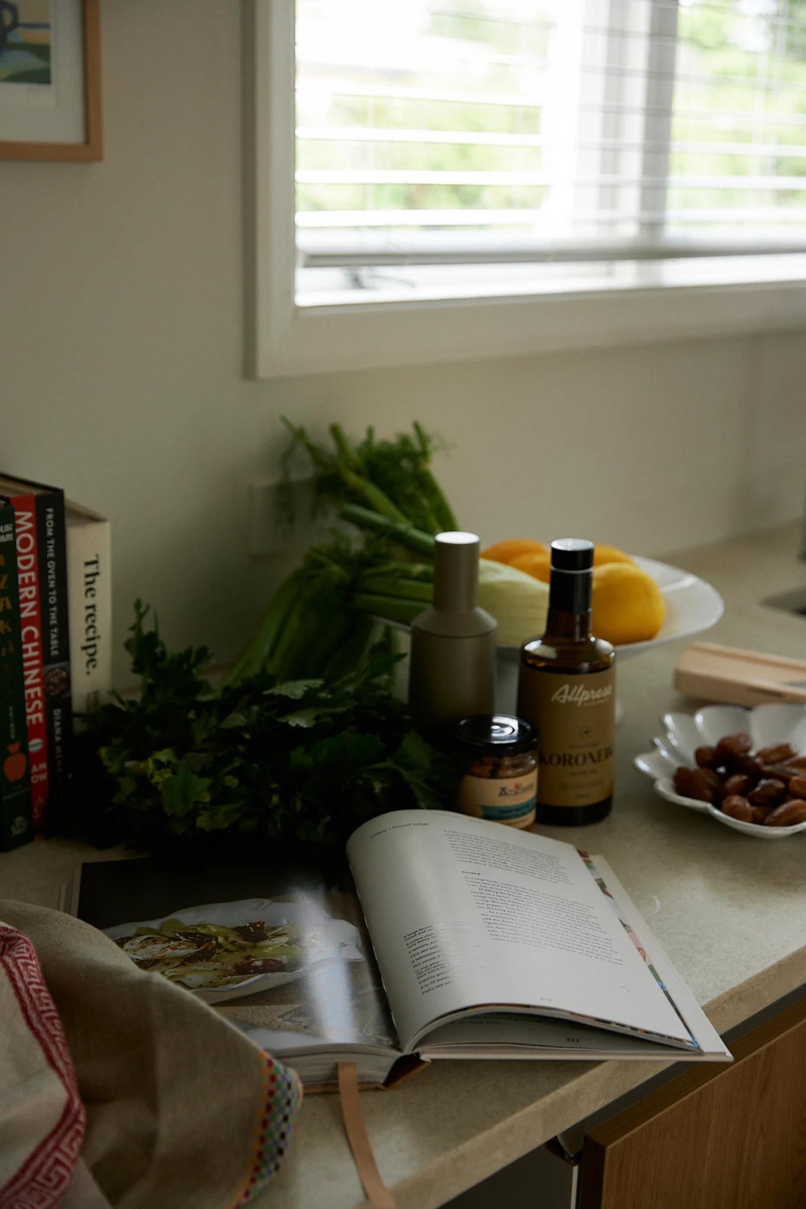 Ingredients for salad recipe sit on bench next to an open cookbook