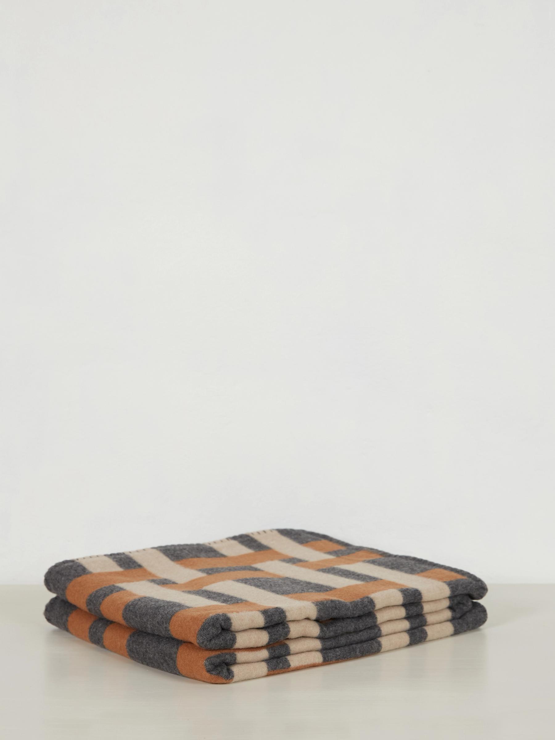 a folded throw with brown and beige stripes