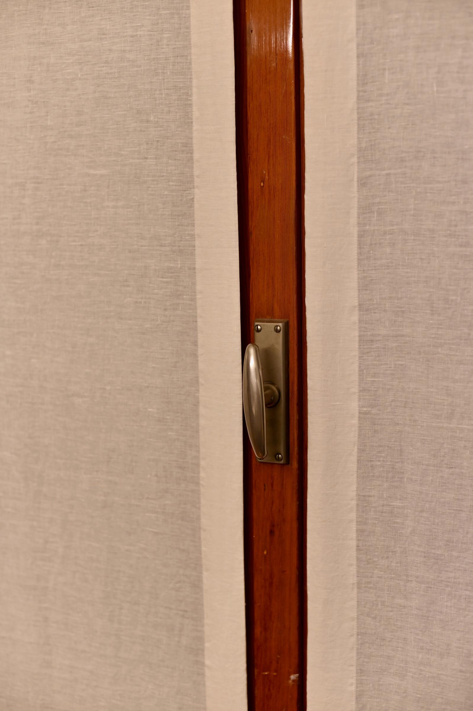 linen curtains on a wooden framed door and metal handle
