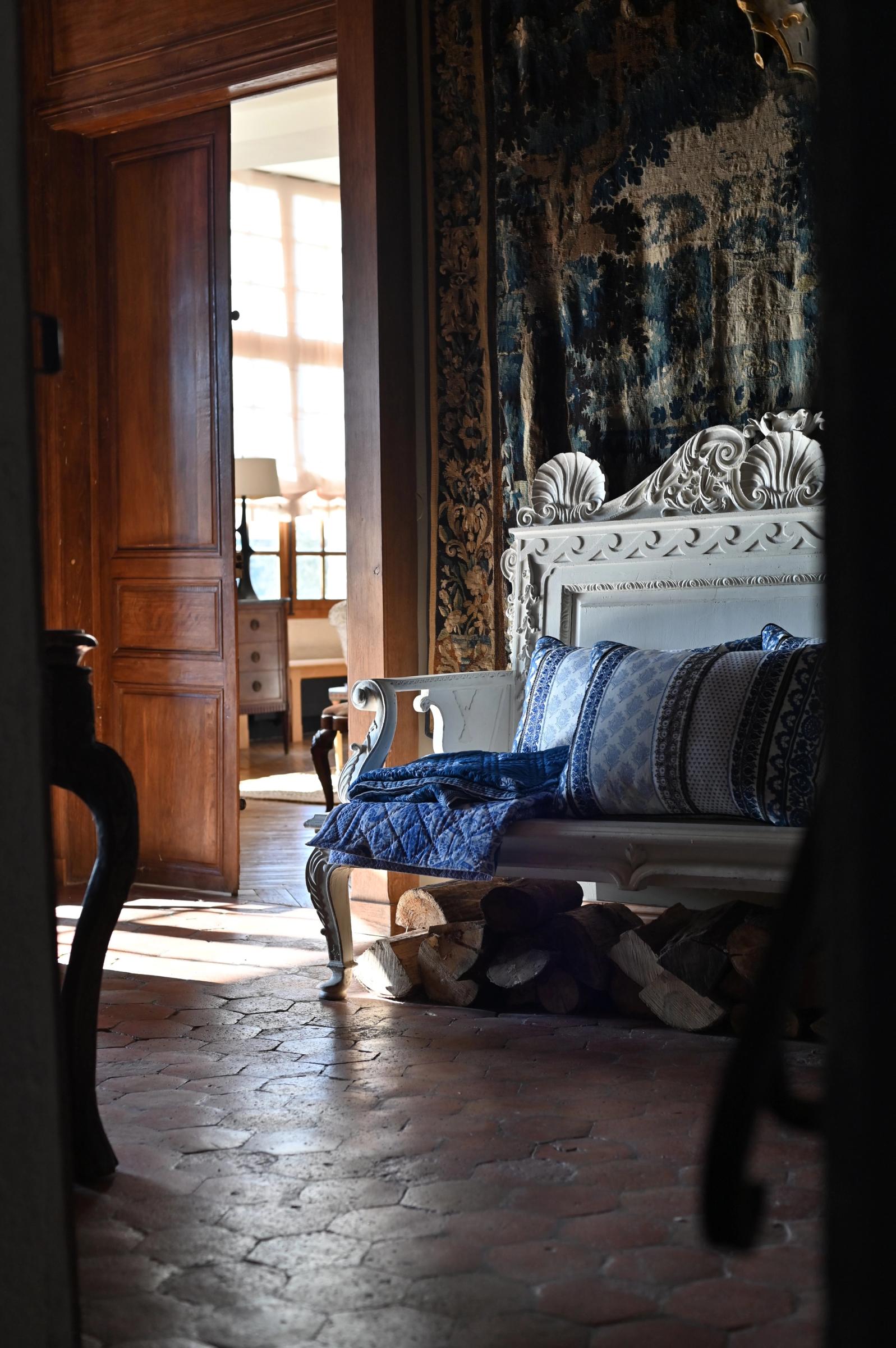 a wooden bench seat on terracotta tiles in the hallway