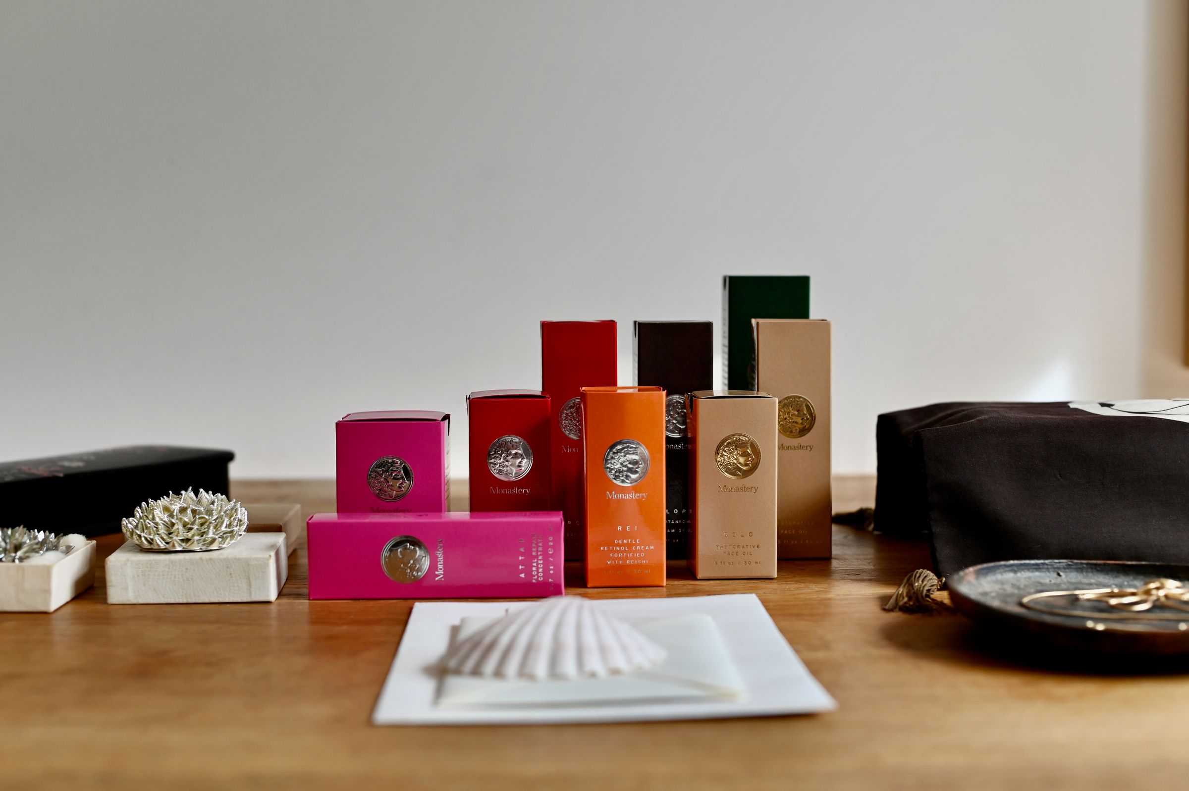 Nine Monastery skincare products in various bottles and boxes, neatly arranged on light-coloured surface.