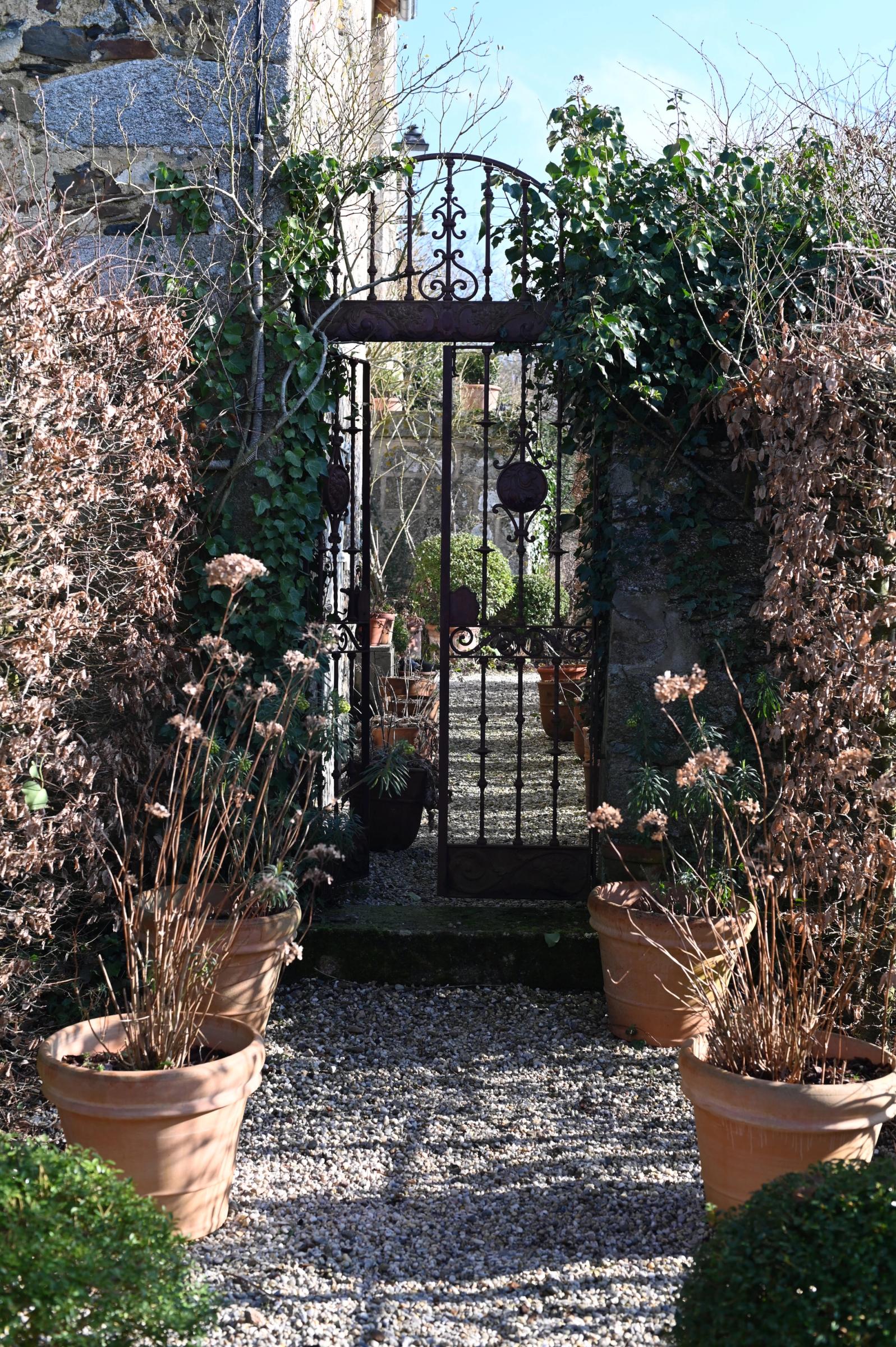 the garden gate and pots of flowers, browned and sleeping through winter