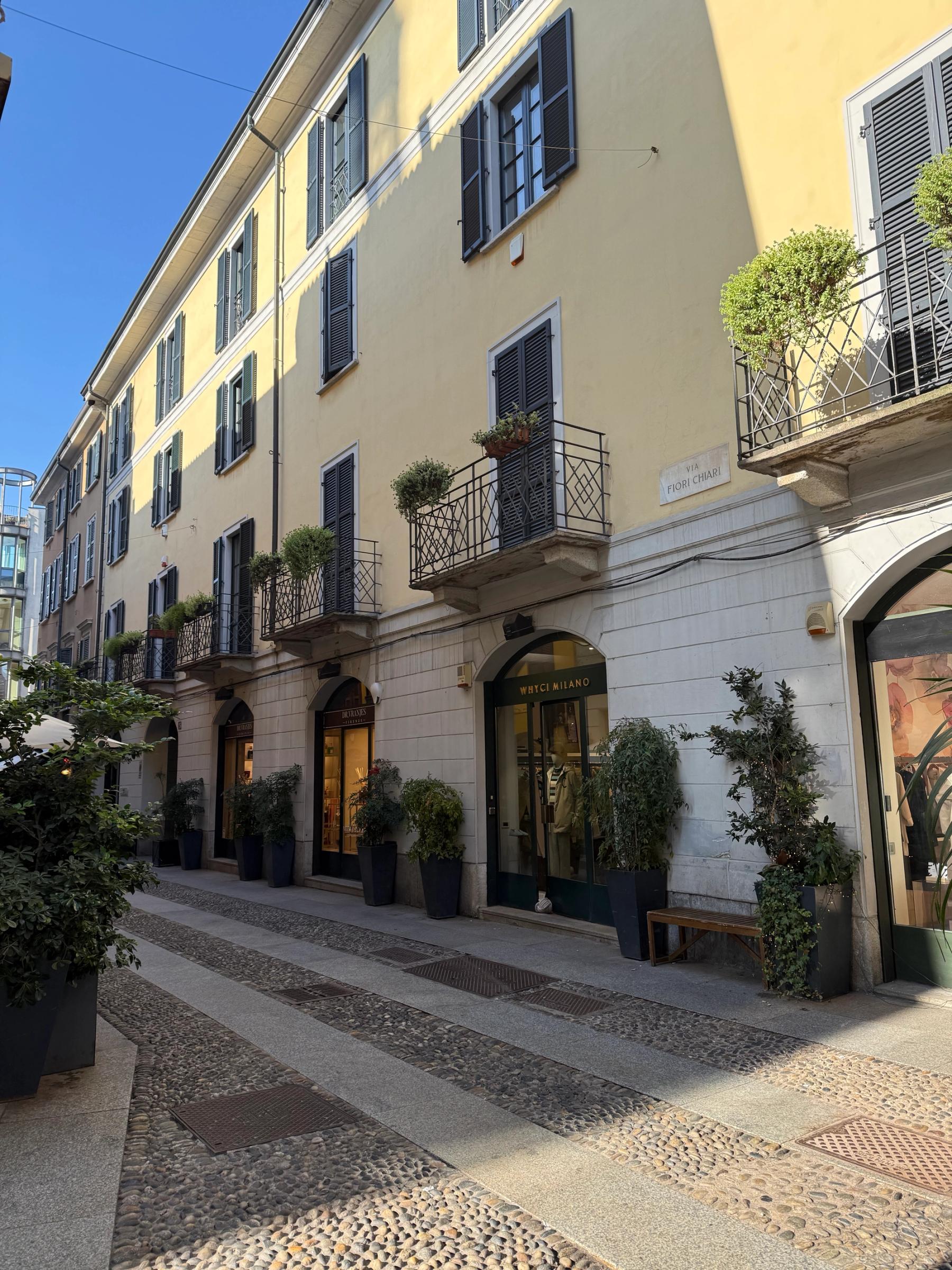 two storey shop fronts in an alleyway with the sun on them