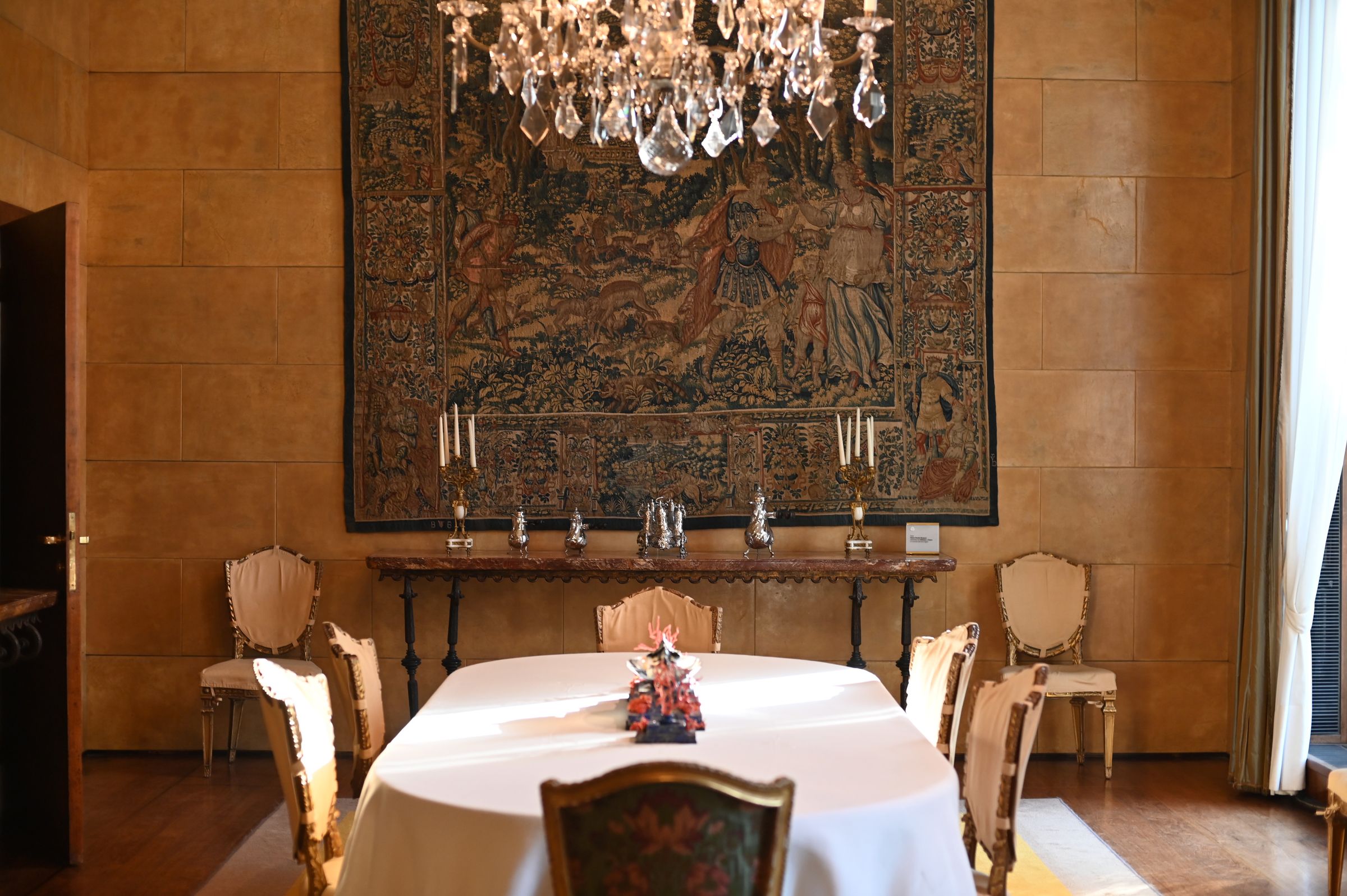the dining room with a white tablecloth and glass chandelier