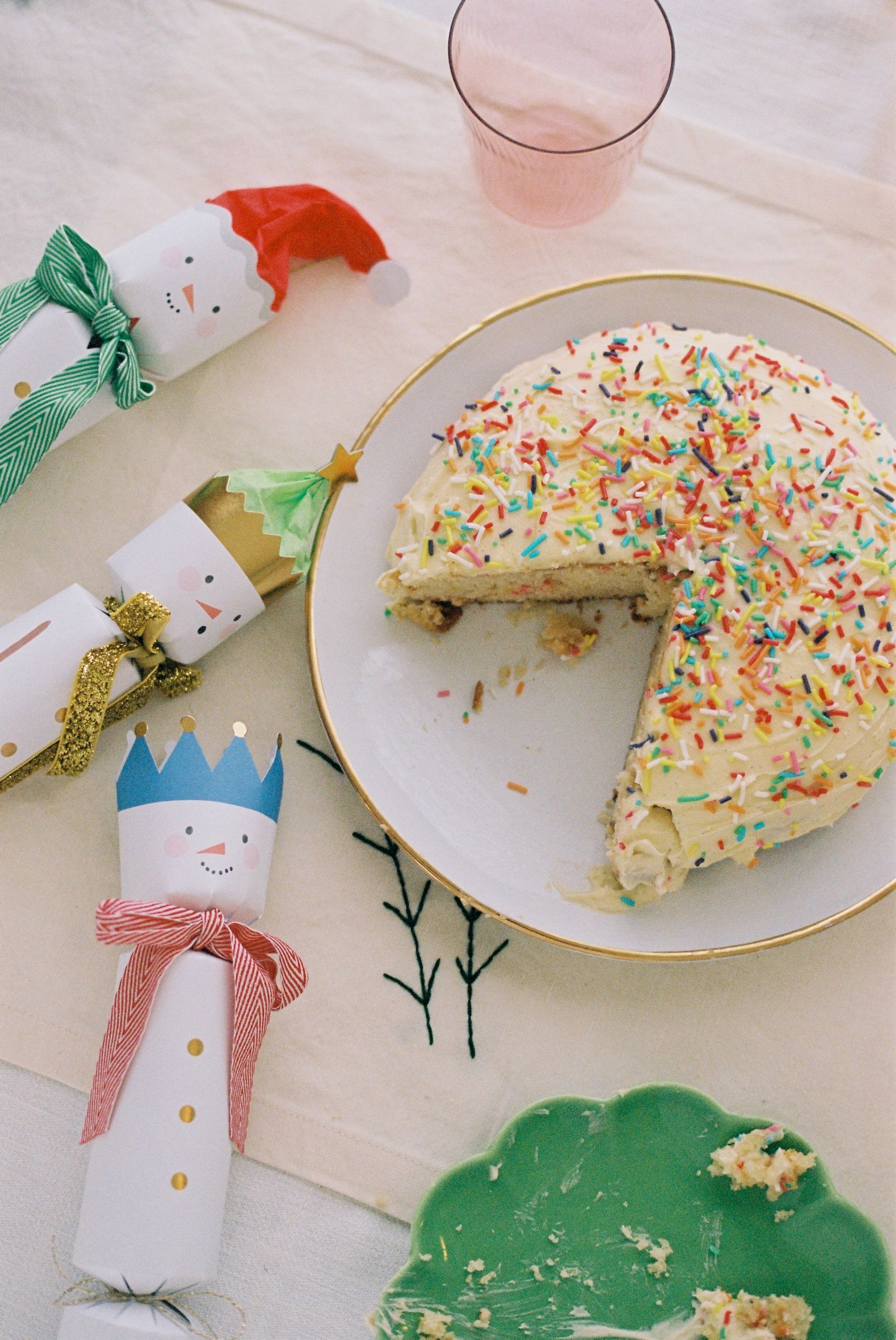 a festive table with a white plate and sprinkles cake