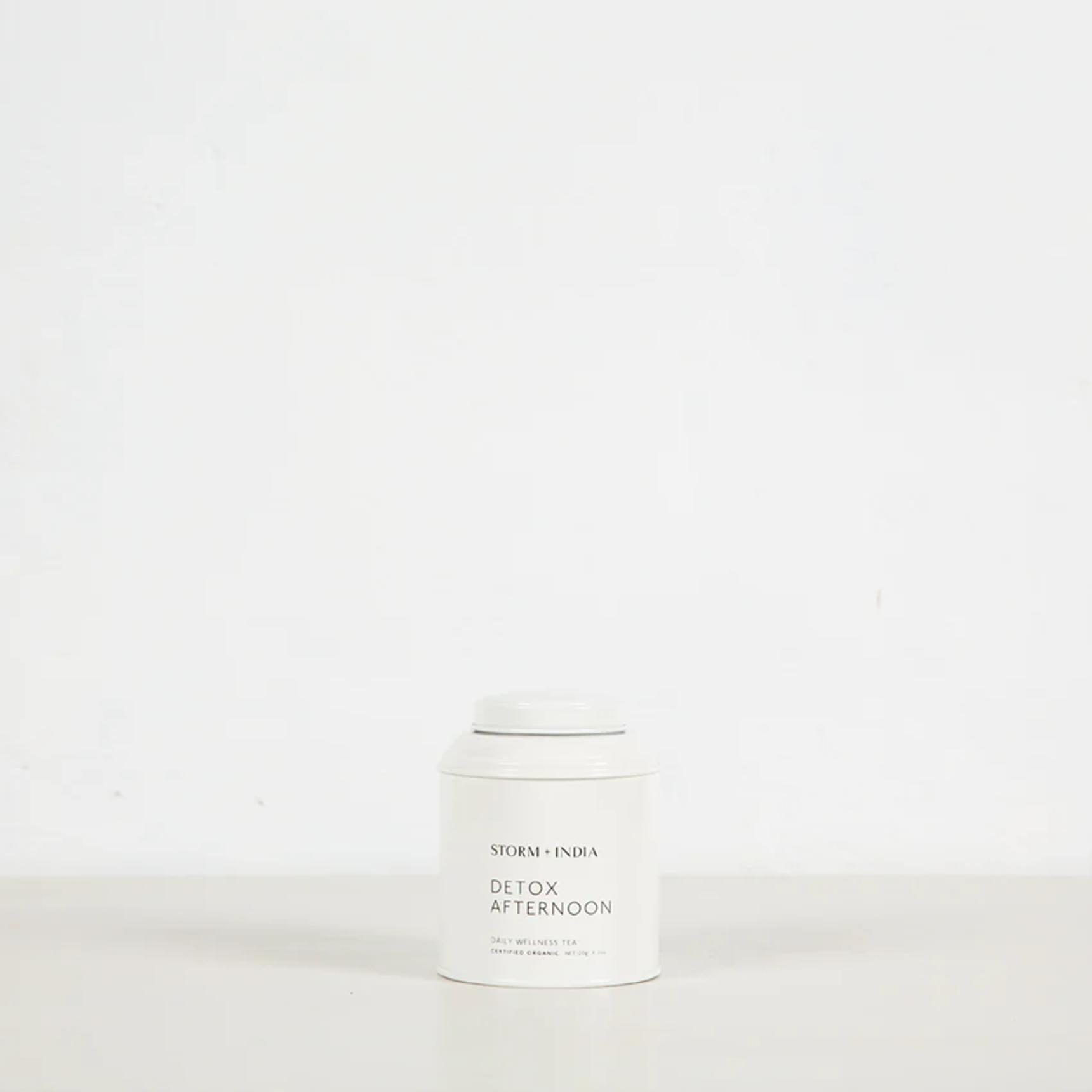 White "STORM + INDIA DETOX AFTERNOON" tea canister on light surface against white background. Minimalist design emphasises clean, simple aesthetic.