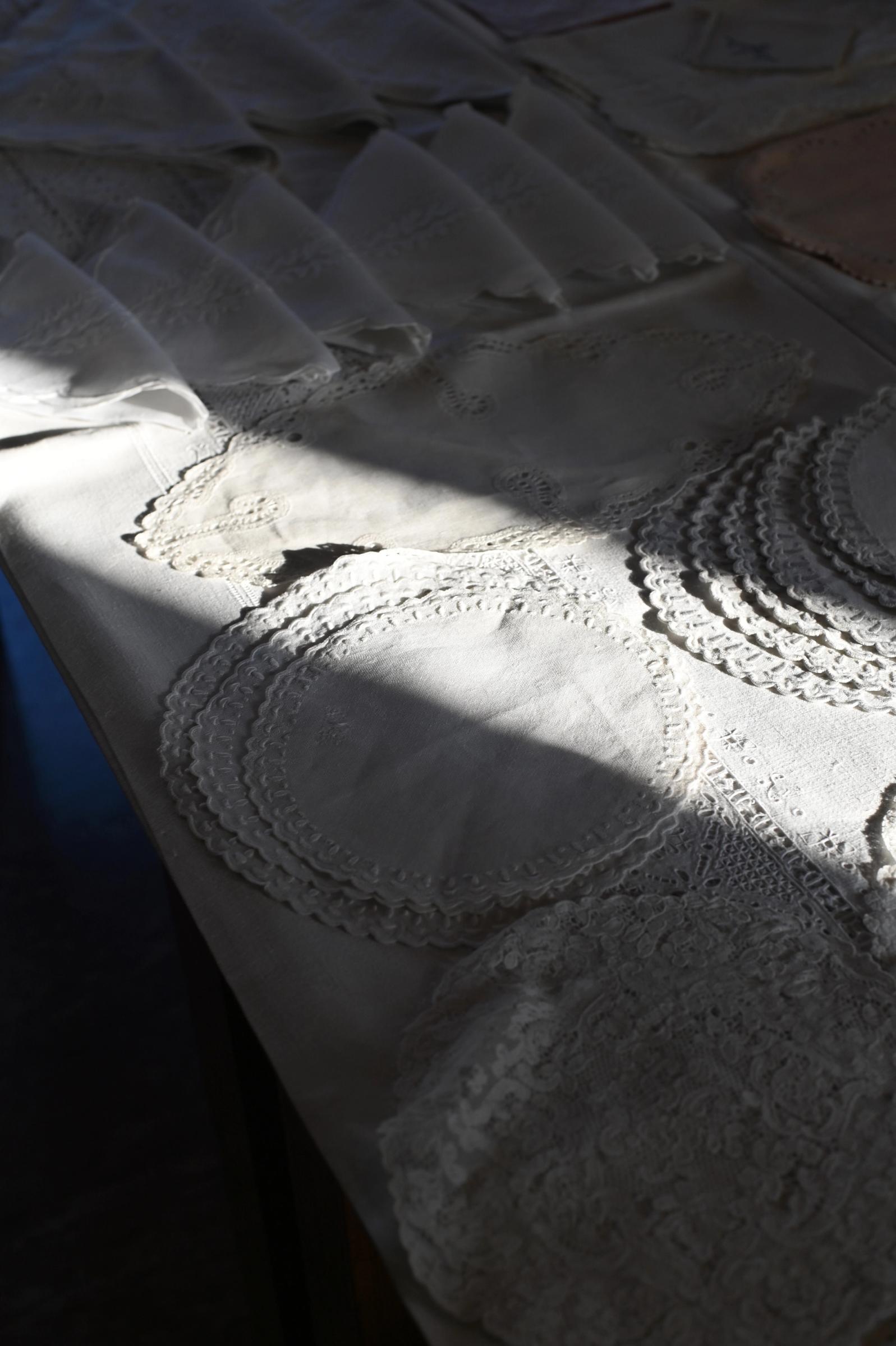 small linen napkins are folded and laid out over a table in the sun