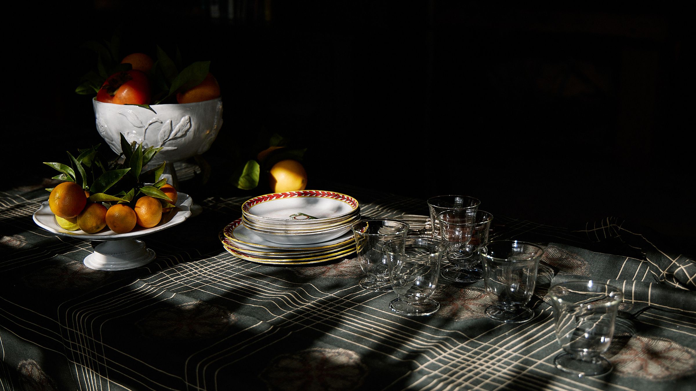 Dining table with dark linen cloth and white ceramics