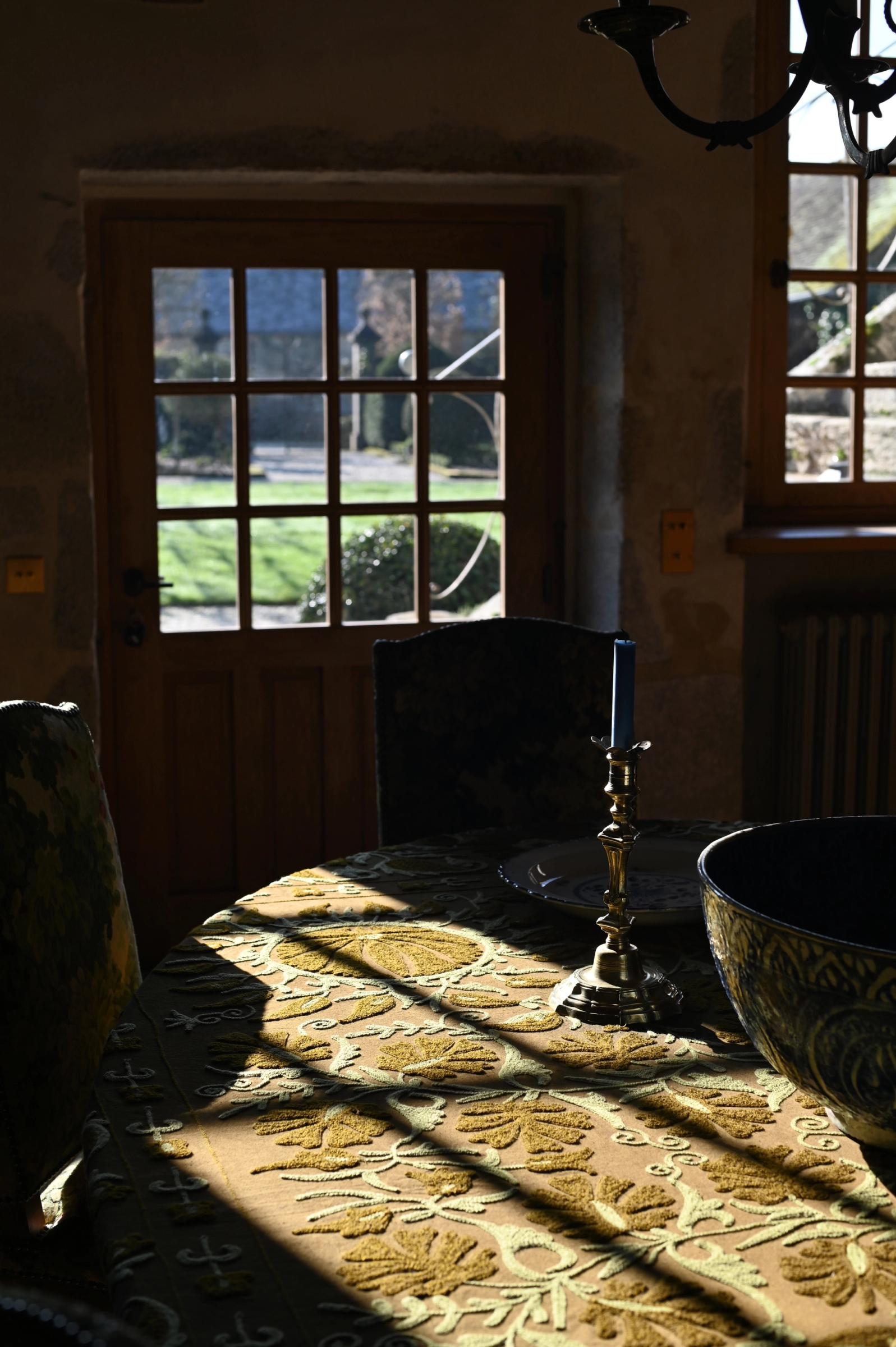 sunlight pours over a green textile covered dining table