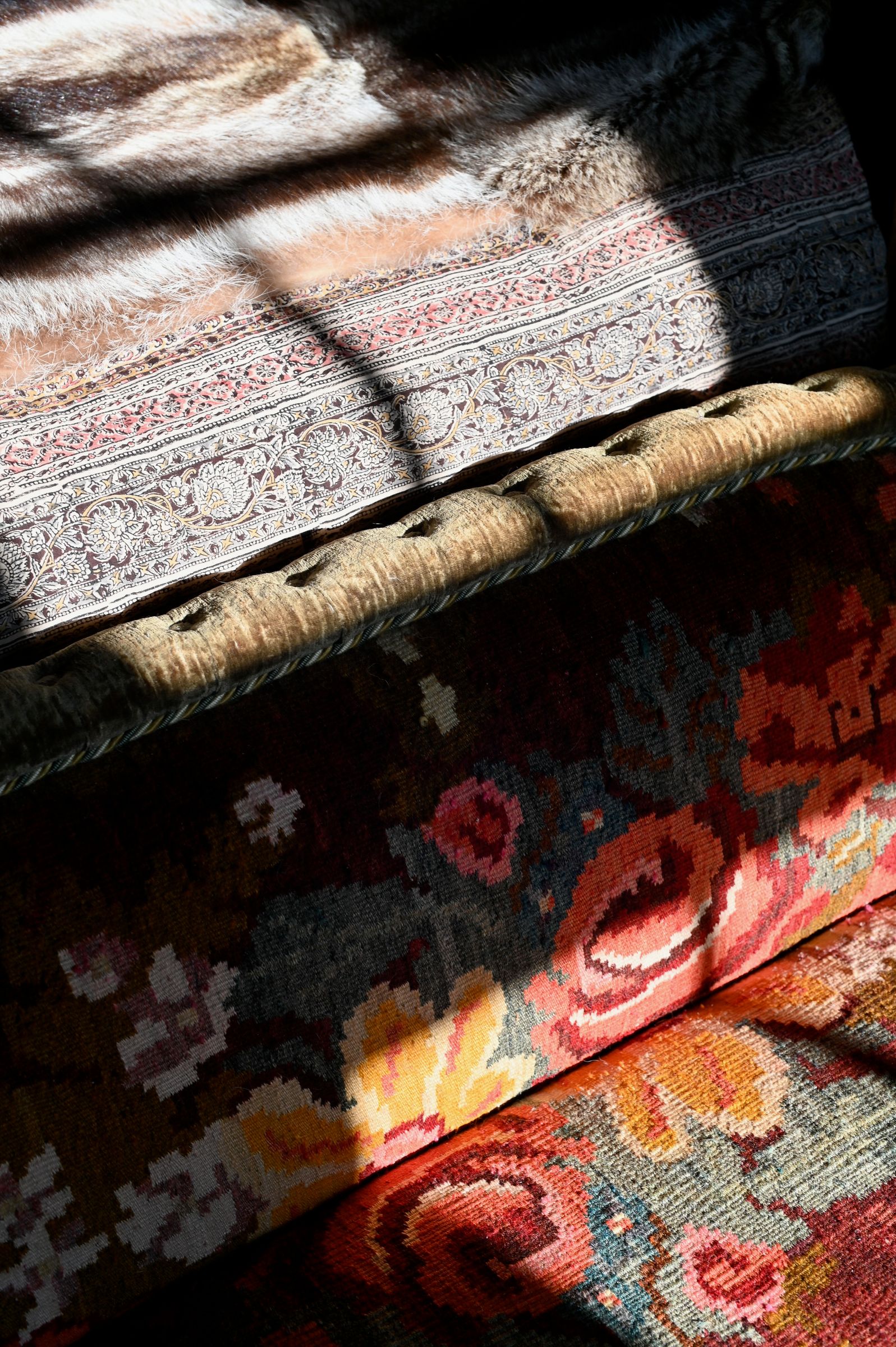close up of textiles on the bed in red gold and orange
