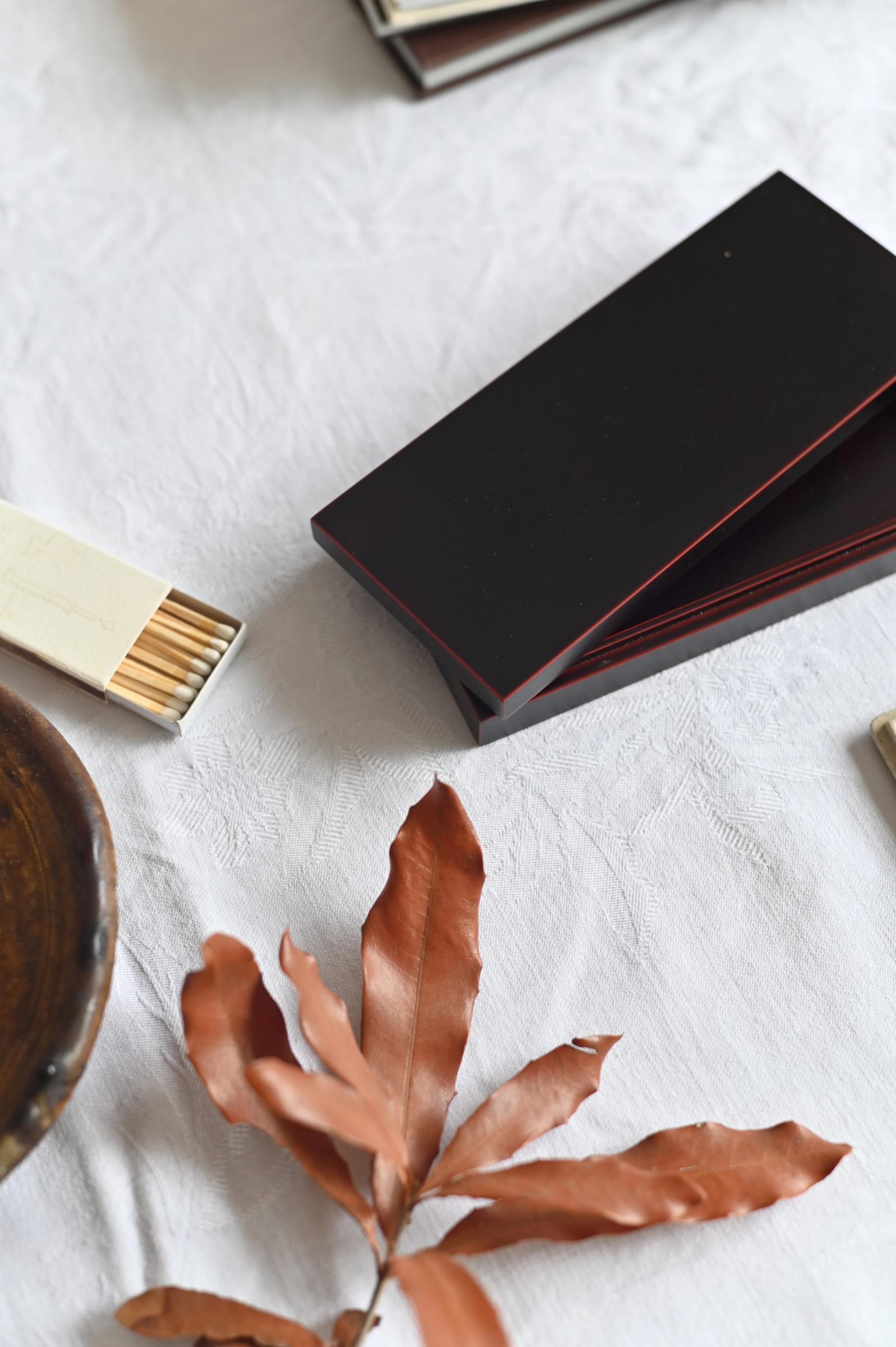 black lacquer box sits on table half opened next to a box of matches