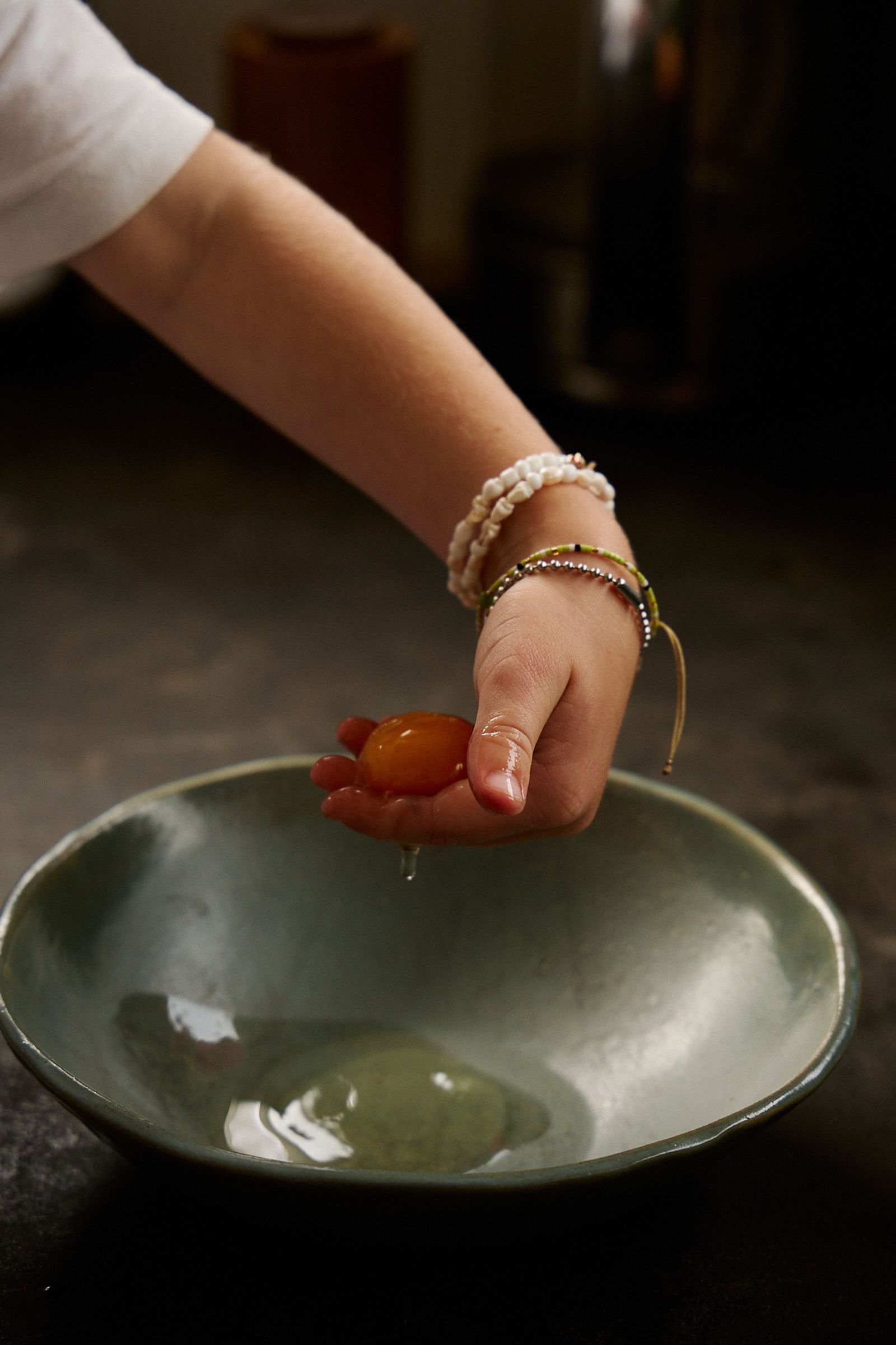 small boy's hand holding a fresh egg yolk