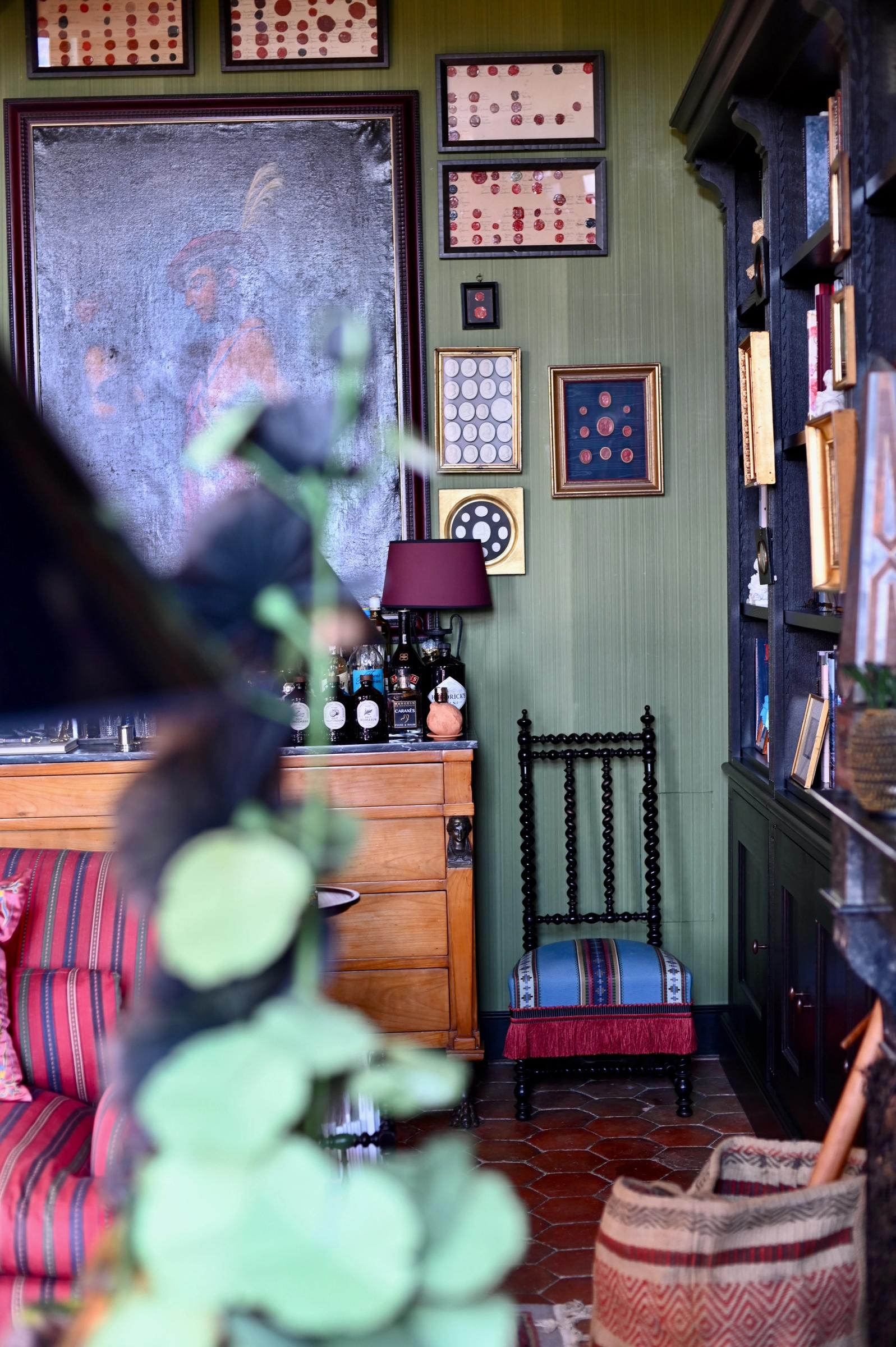 a view of the main sitting room with green walls and antique artworks