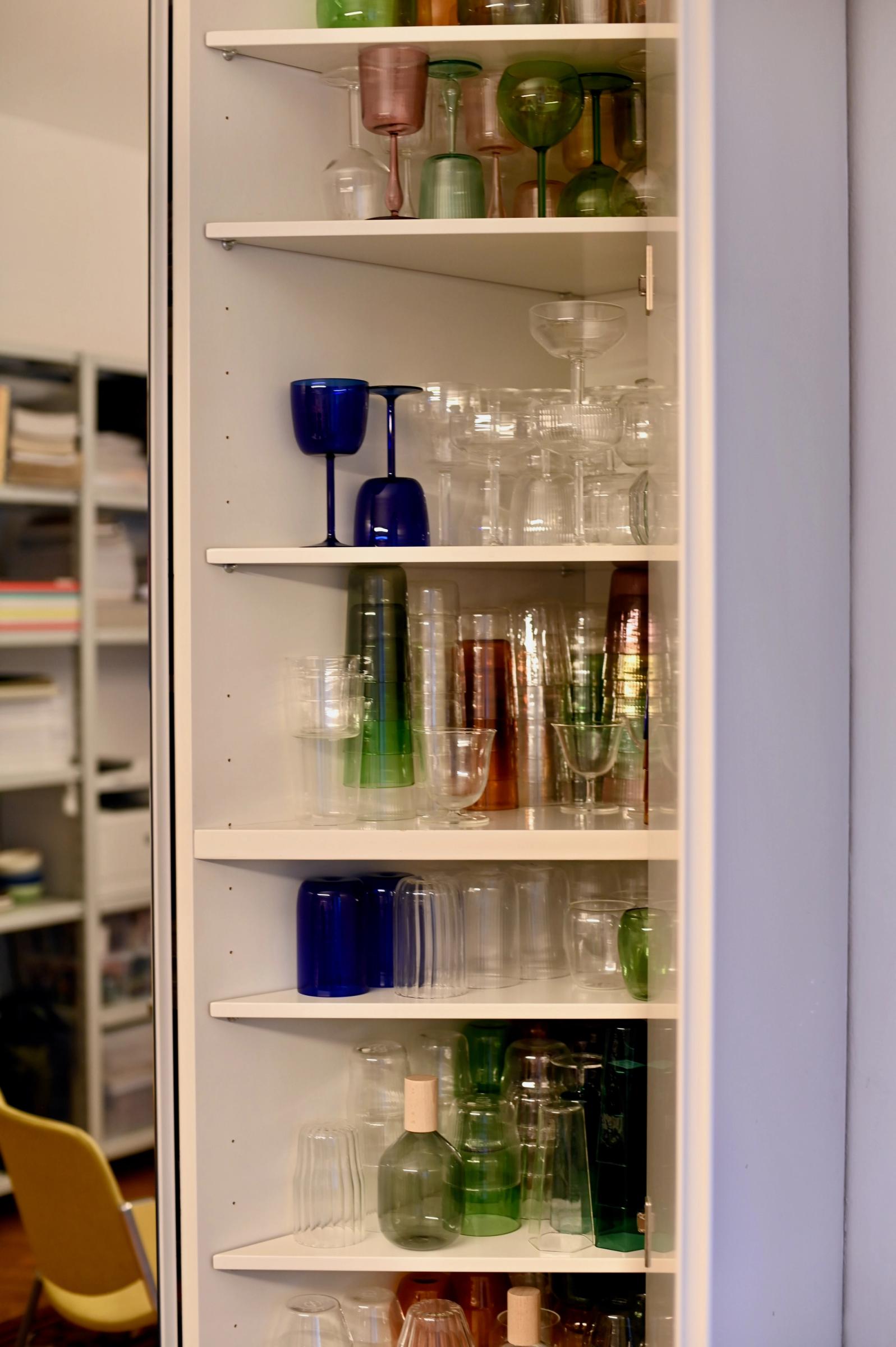 a cupboard filled with vintage and coloured glassware