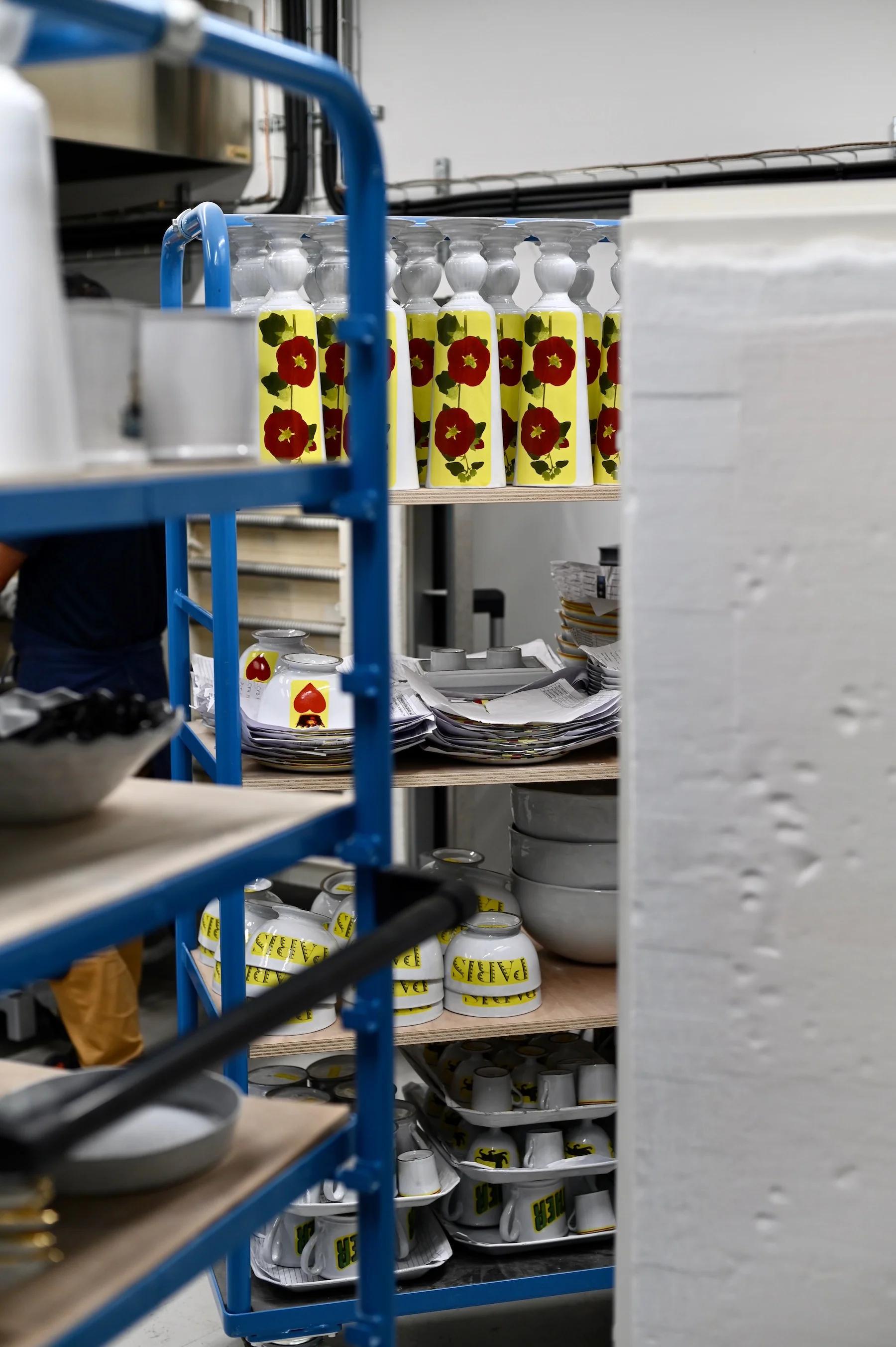 Cluttered storage area with shelves holding colourful bottles and stacked plates. Metal rack and large white structure in foreground.Cluttered storage area with shelves holding colourful bottles and stacked plates. Metal rack and large white structure in foreground.Cluttered storage area with shelves holding colourful bottles and stacked plates. Metal rack and large white structure in foreground.Cluttered storage area with shelves holding colourful bottles and stacked plates. Metal rack and large white structure in foreground.Cluttered storage area with shelves holding colourful bottles and stacked plates. Metal rack and large white structure in foreground.