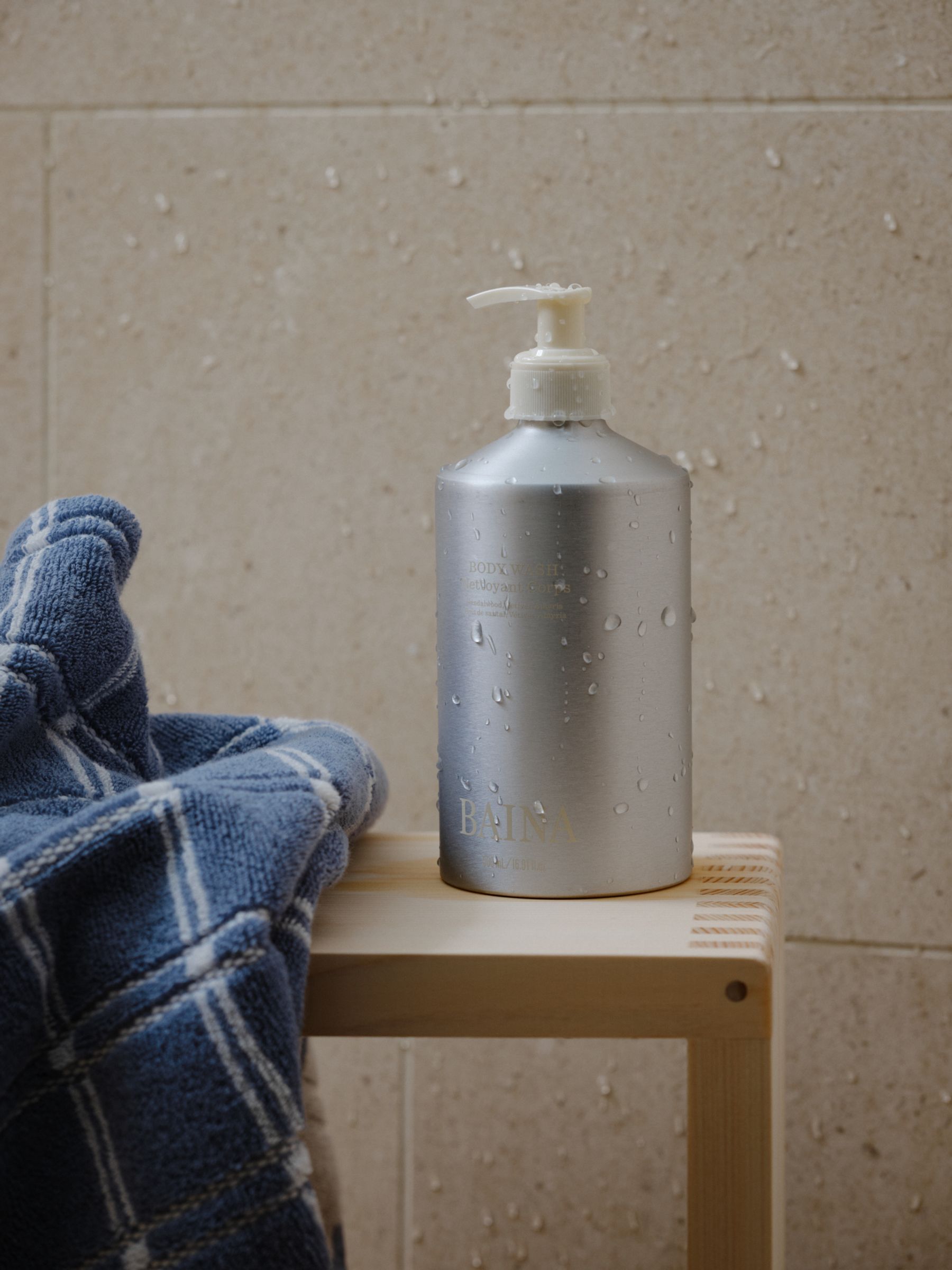 a hand towel sits on the basin next to Baina skincare product