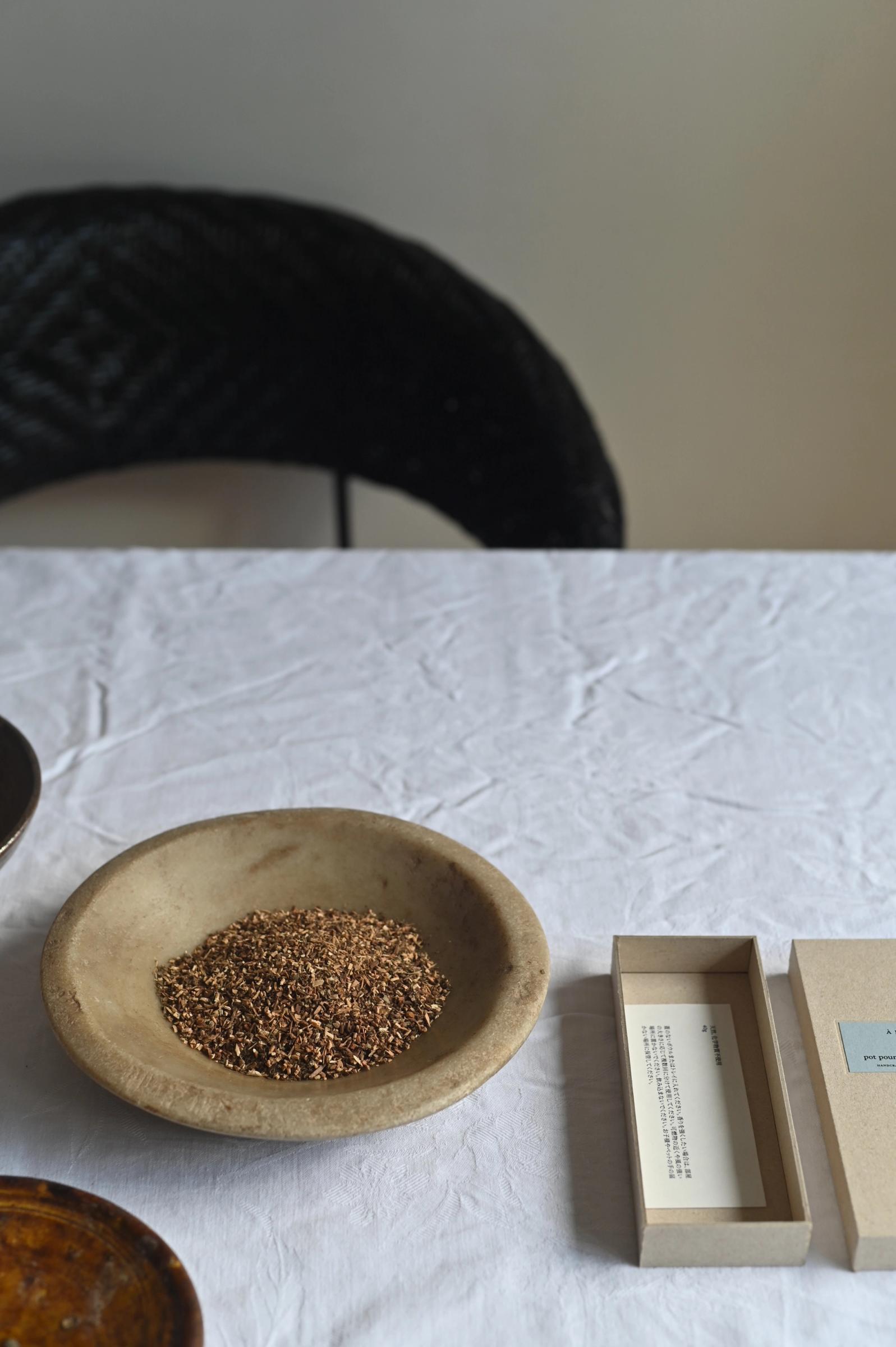 bowl of potpouri sits next to its packaging cardboard box with blue label