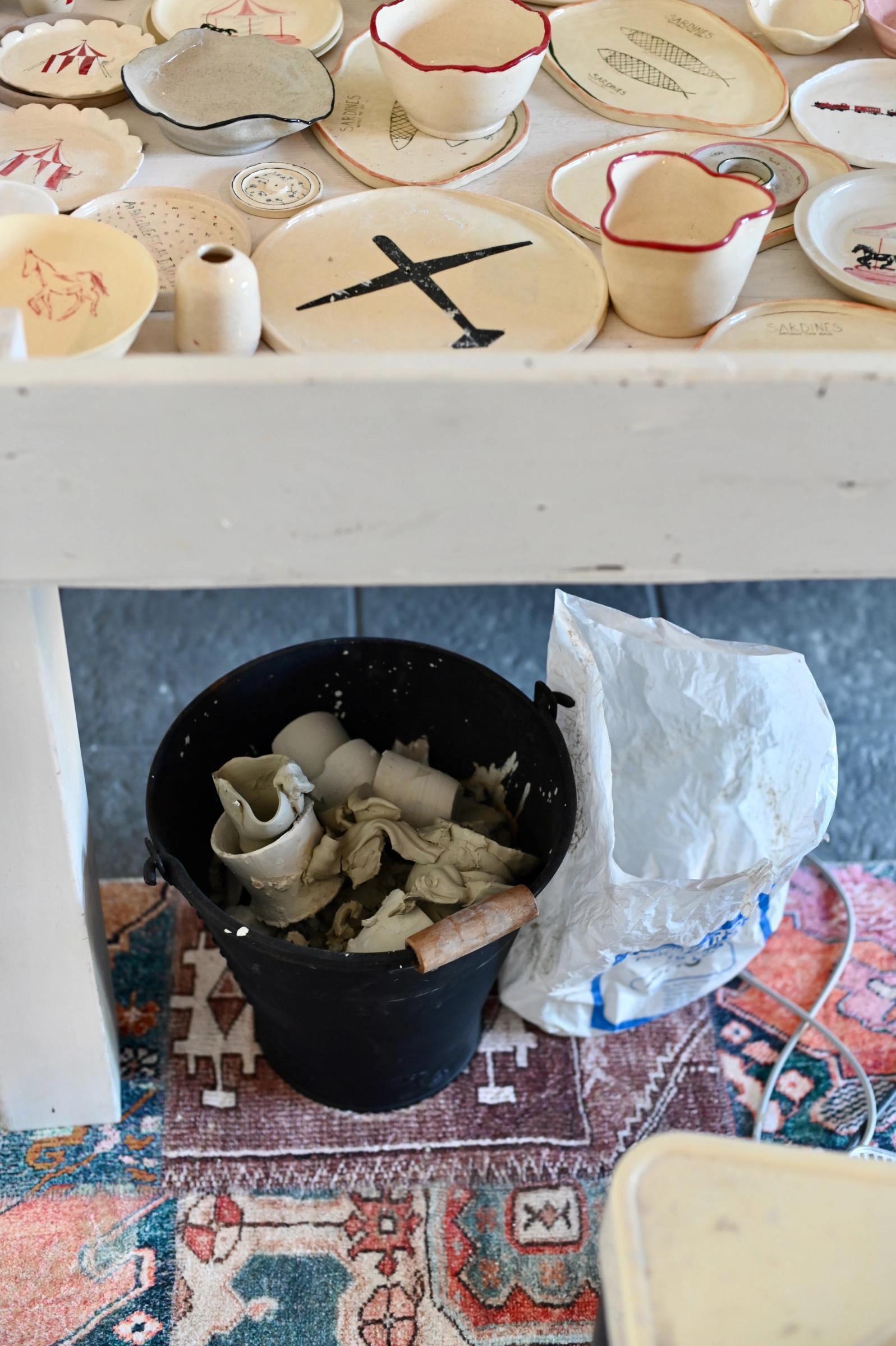 a working space includes finished products and clay thrown into bin