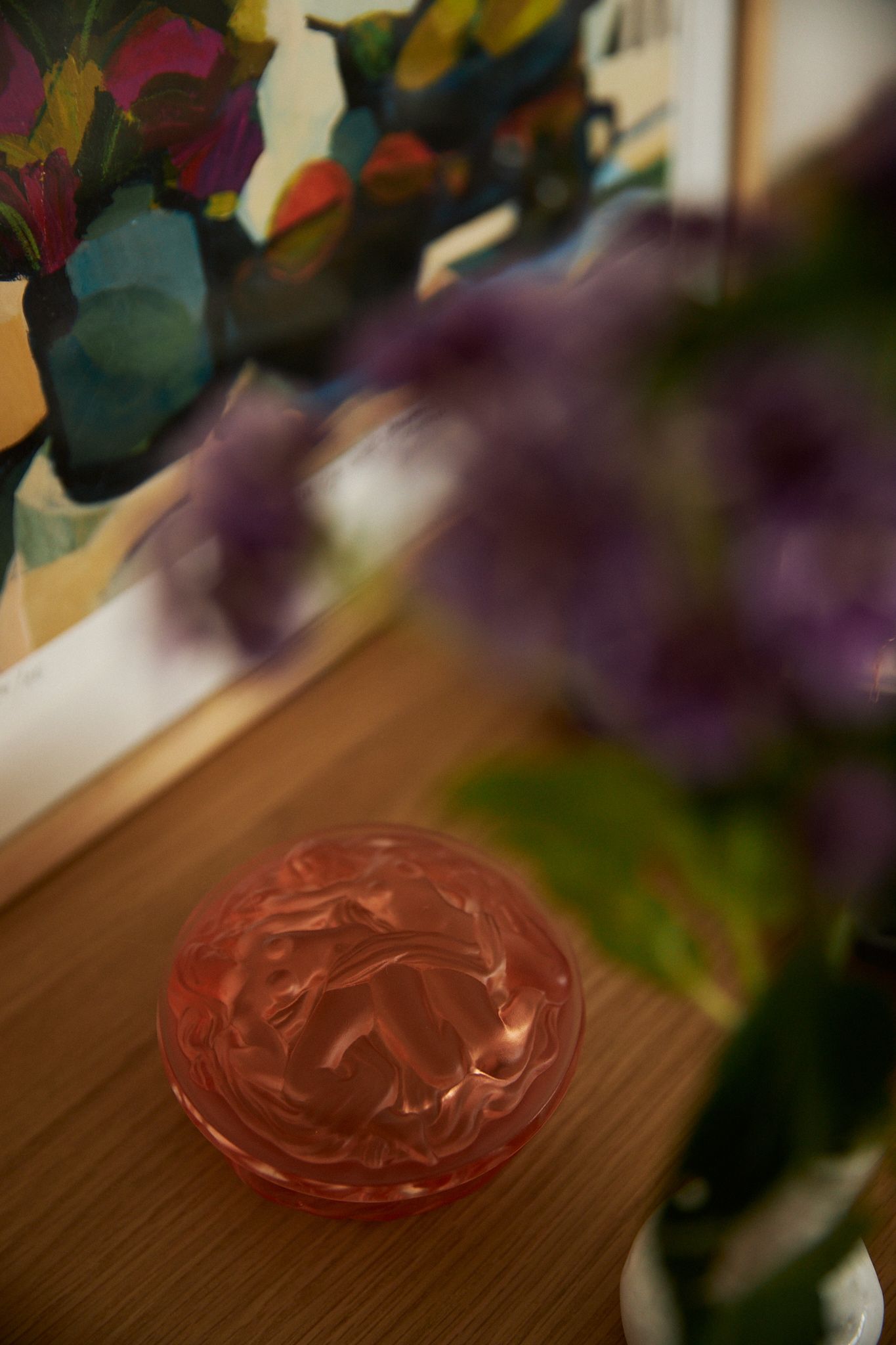 blurred flower obstruct the view of amber glass container on a dresser top counter