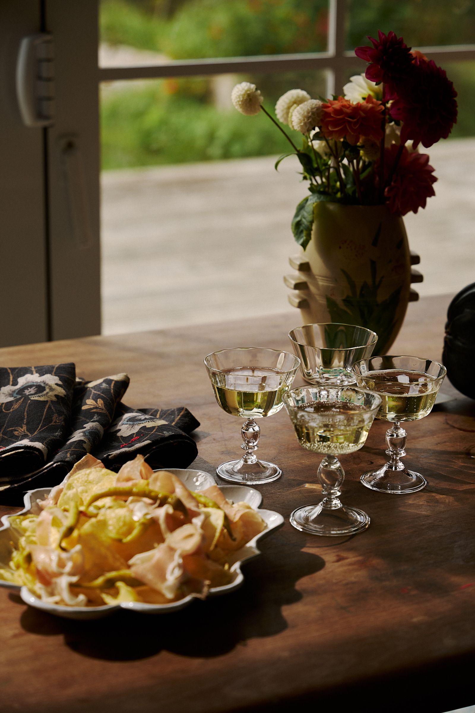 Akua champagne glasses on the dining table with snacks