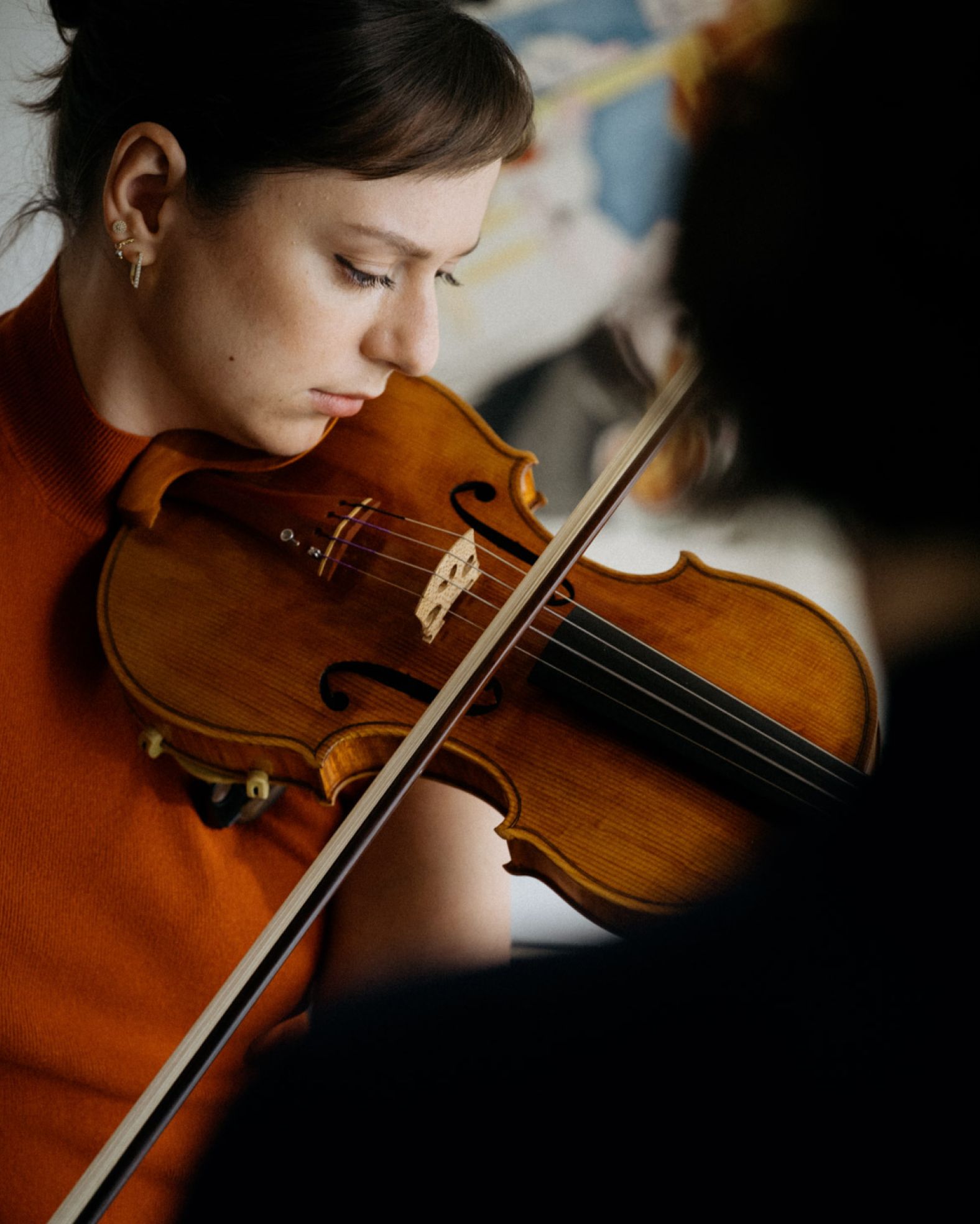 Woman playing the violin with focus