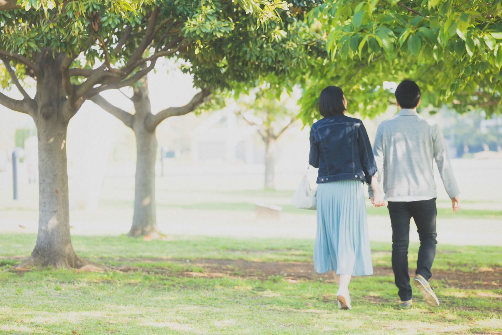 A Japanese couple holding hands in a park